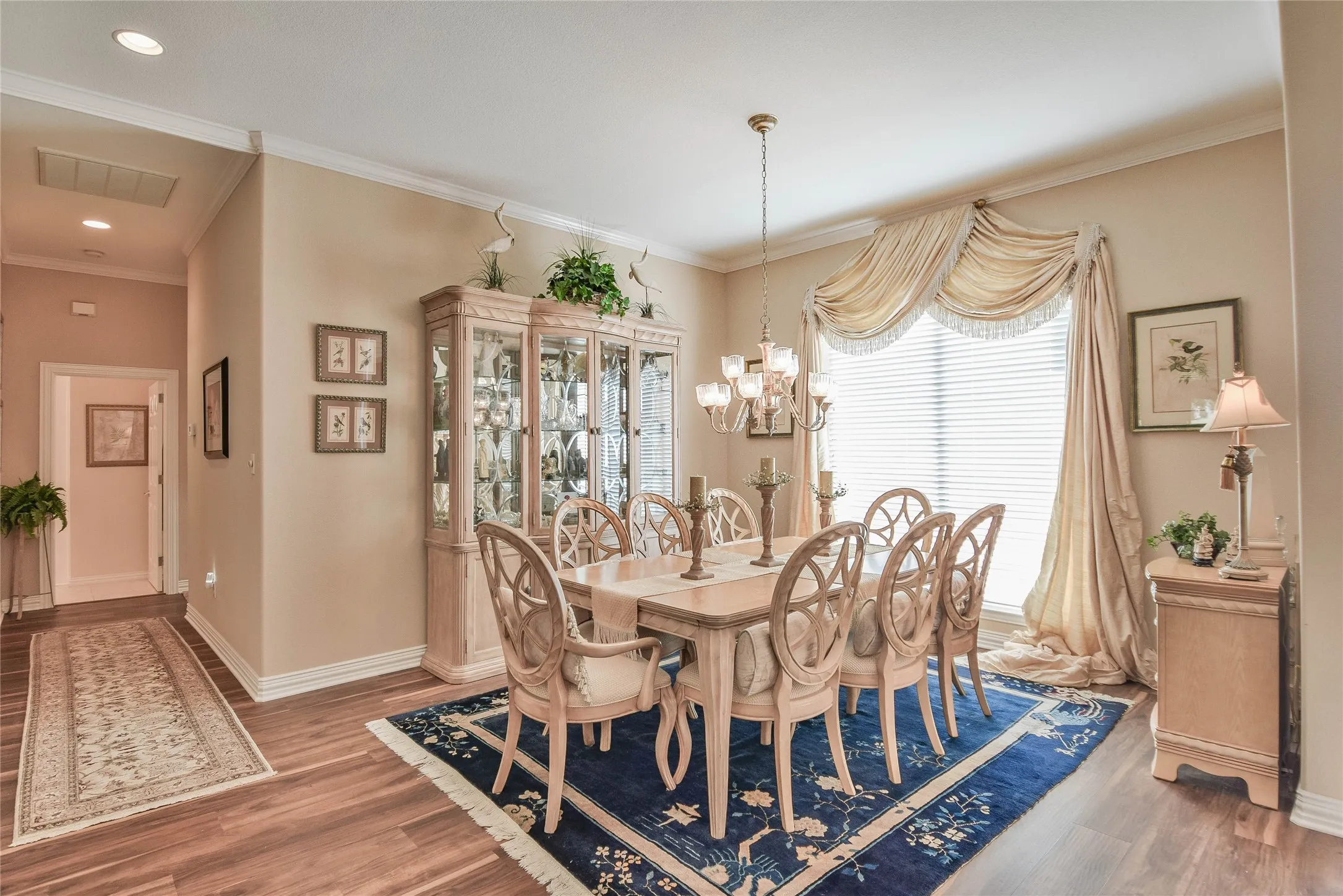 Dining space with wood finished floors, crown molding, a chandelier, and recessed lighting