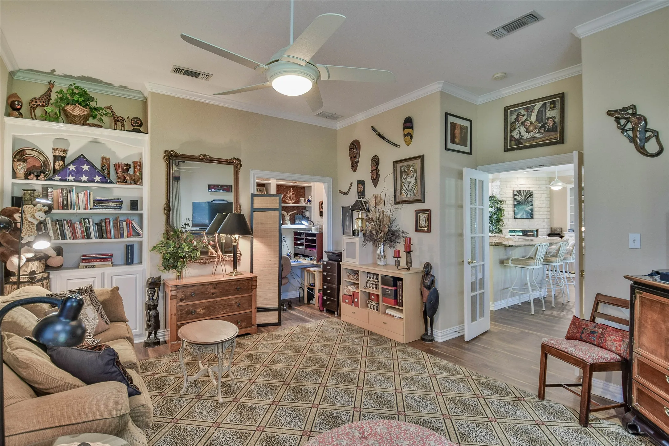 Living area with a ceiling fan, ornamental molding, and wood finished floors