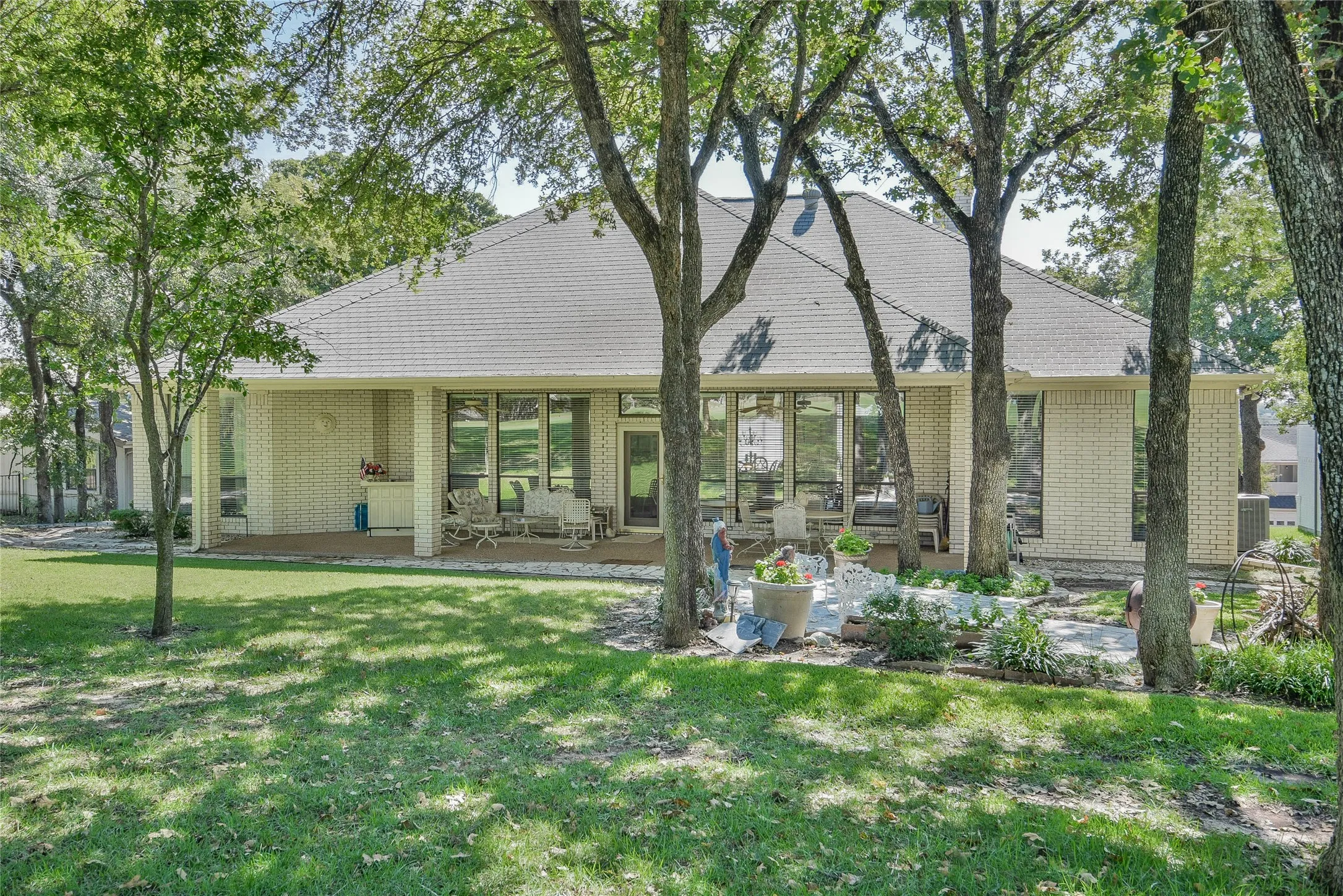 Rear view of house featuring a patio area, a yard, and brick siding