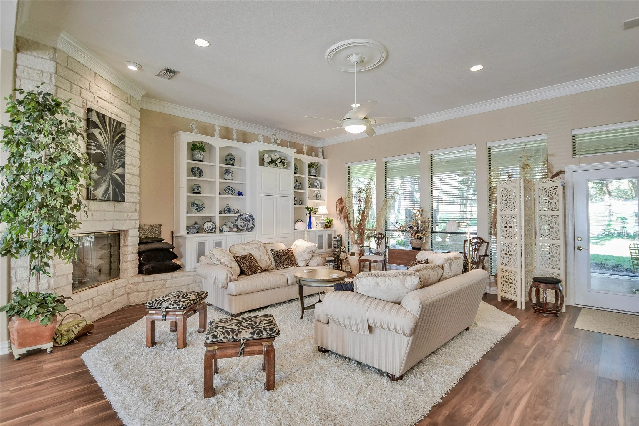 Living area featuring dark wood-style flooring, ornamental molding, a ceiling fan, a fireplace, and recessed lighting