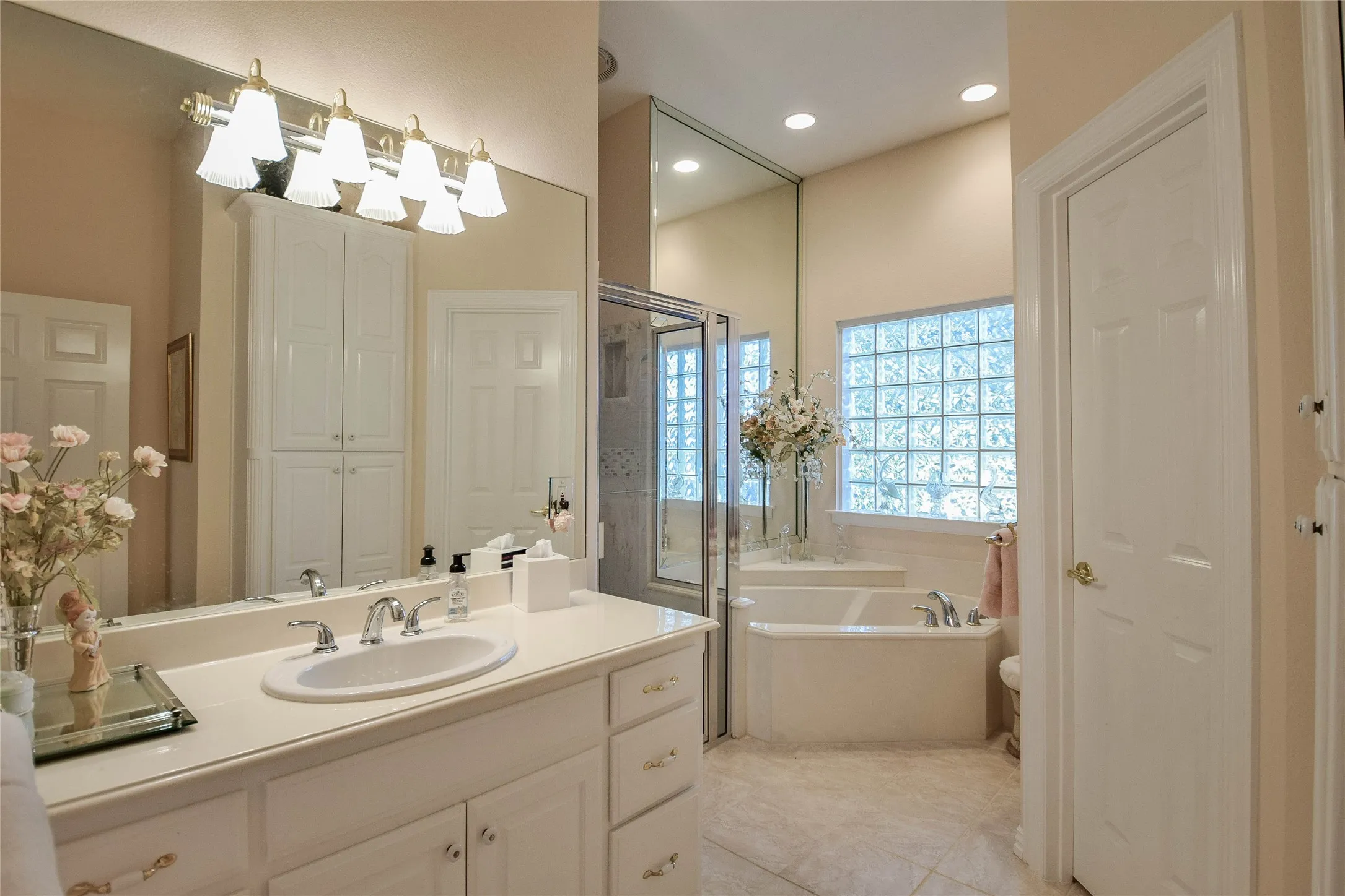 Full bathroom featuring a closet, a garden tub, vanity, a stall shower, and light tile patterned floors