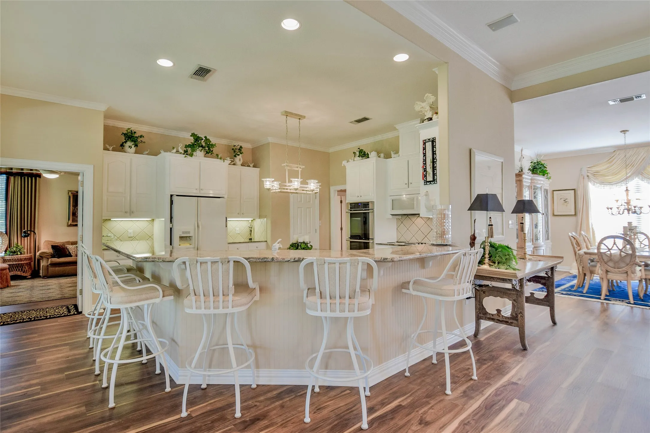 Kitchen with a chandelier, decorative backsplash, crown molding, healthy amount of natural light, and light stone countertops