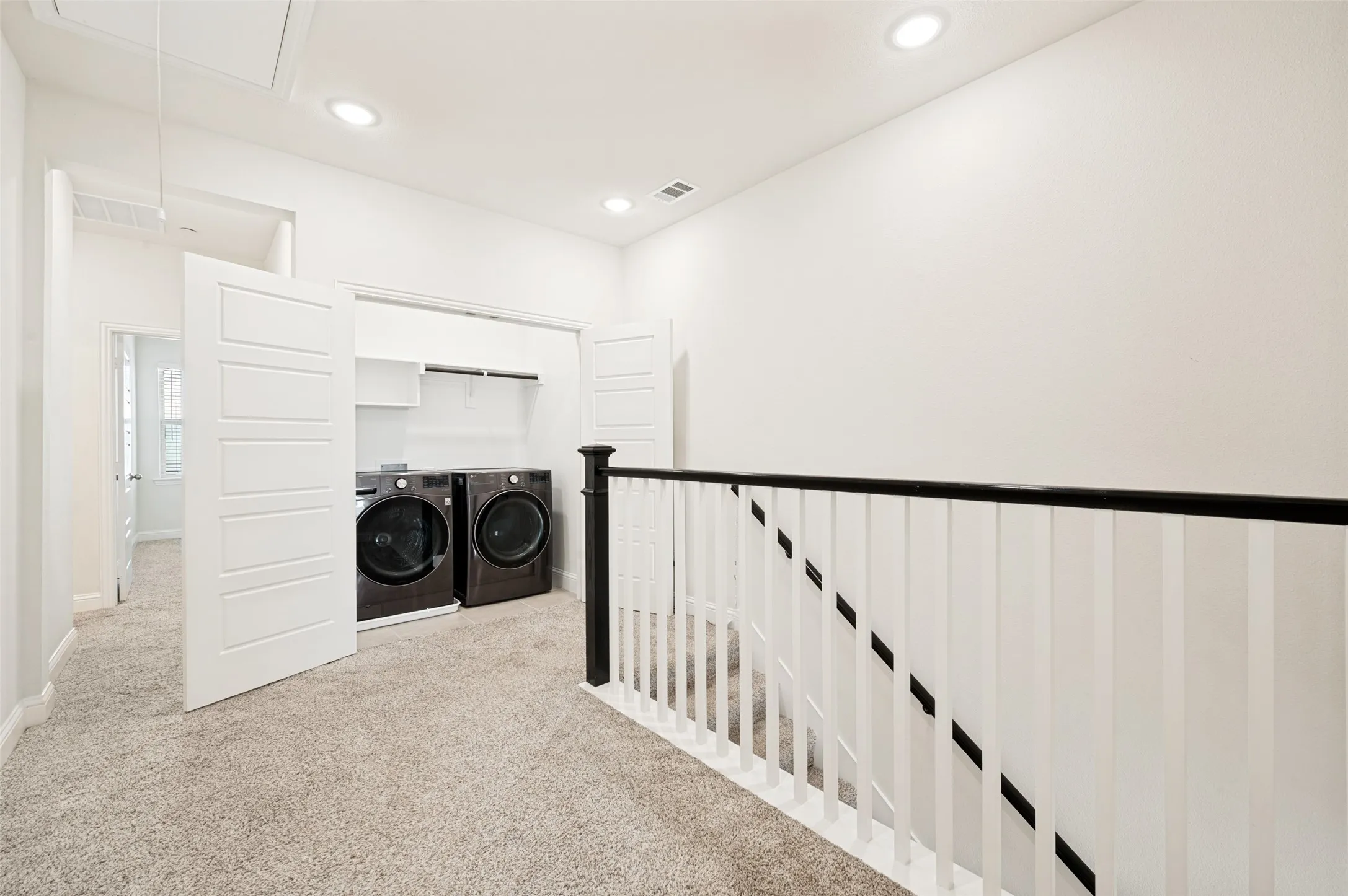 Dedicated laundry closet with front-loading appliances and shelving