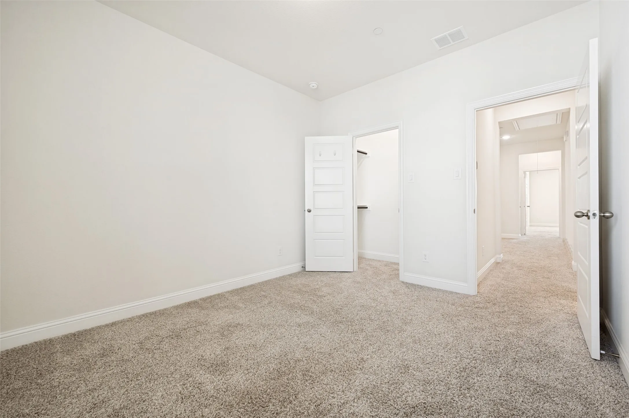 Bright interior space featuring light-toned carpeting and white wall finishes