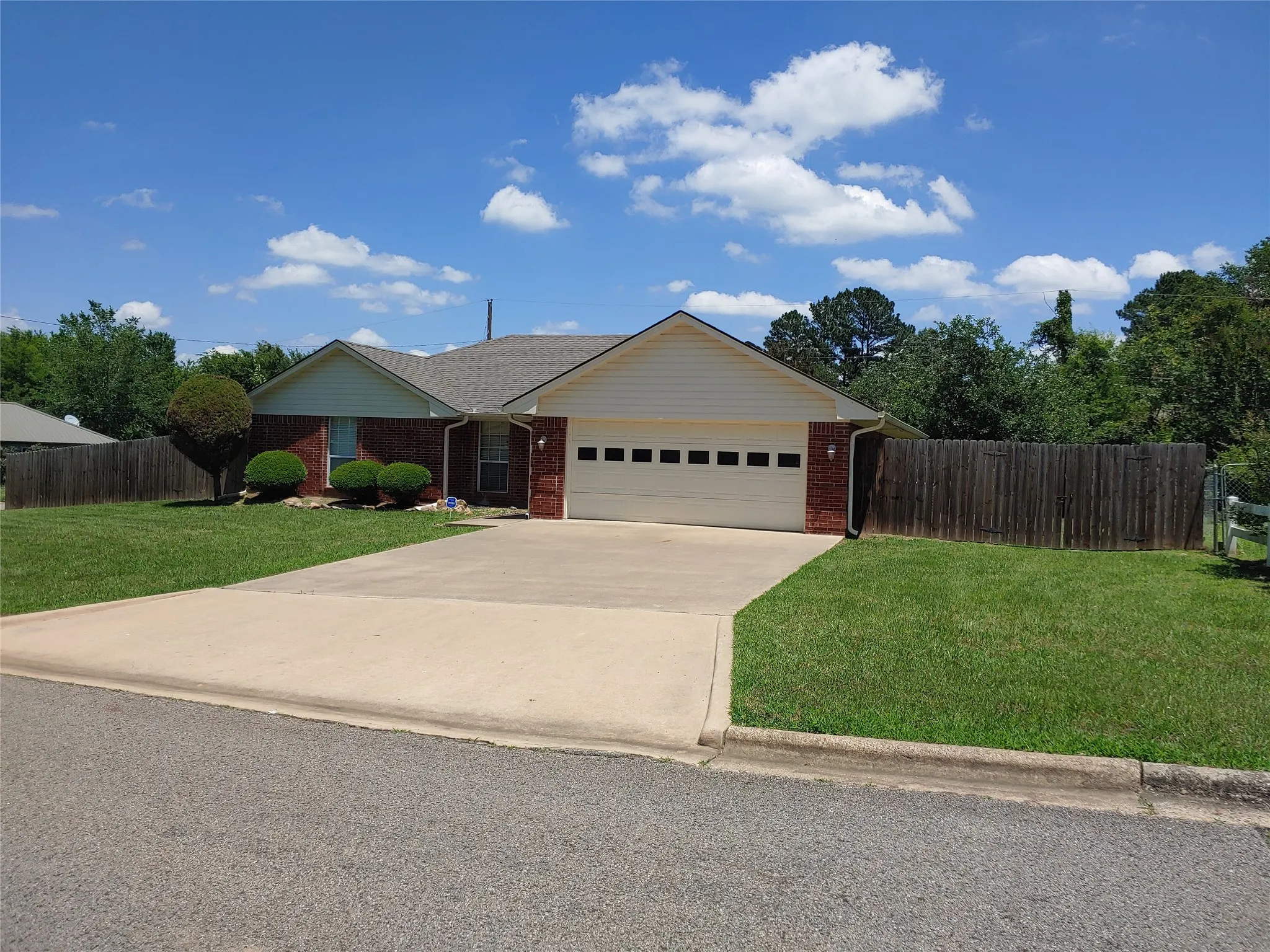Brick and siding single-story residence featuring an attached garage with a panel door