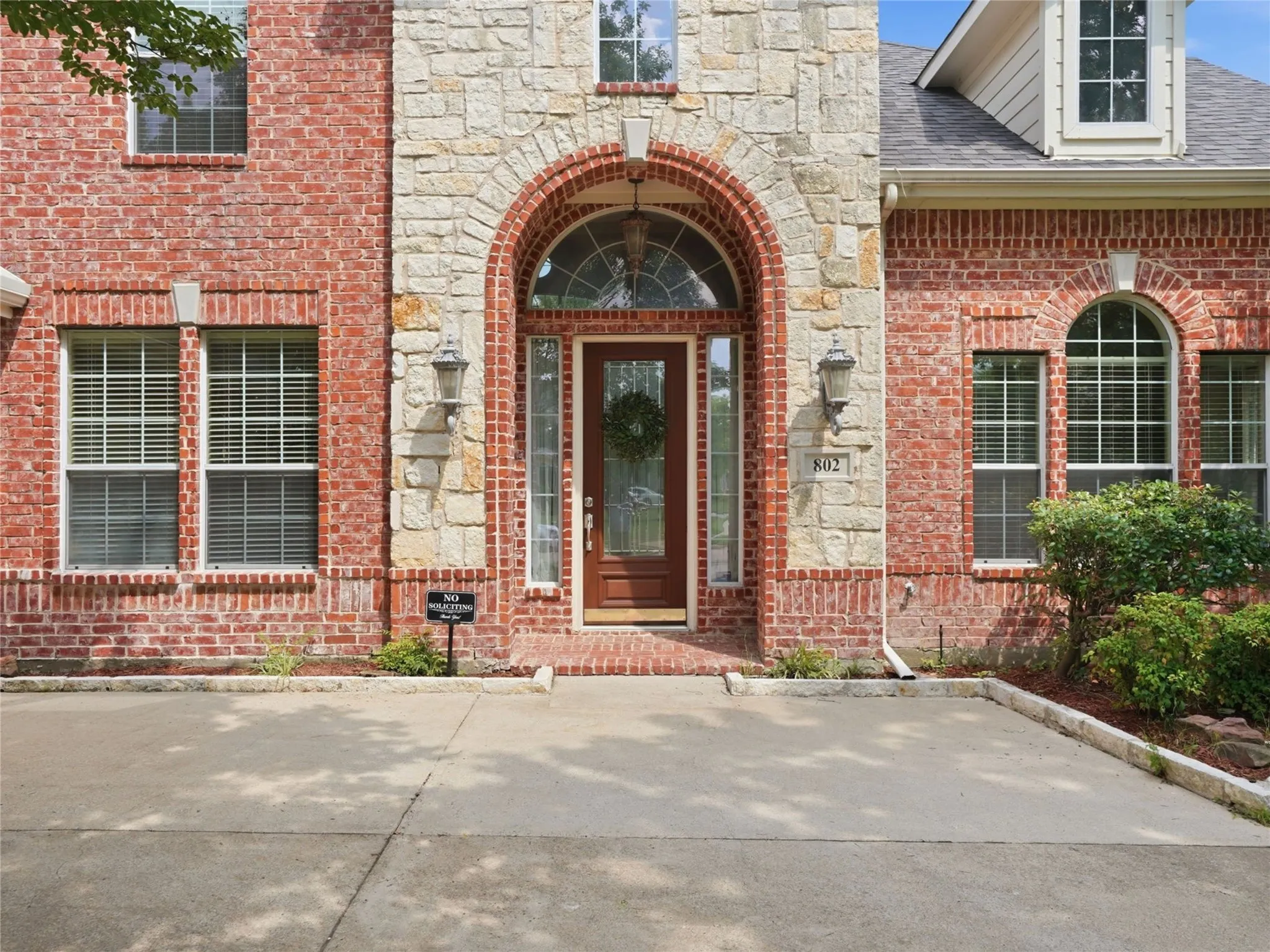The stately arched entrance welcomes guests with timeless architecture and establishes the refined character carried throughout the home.
