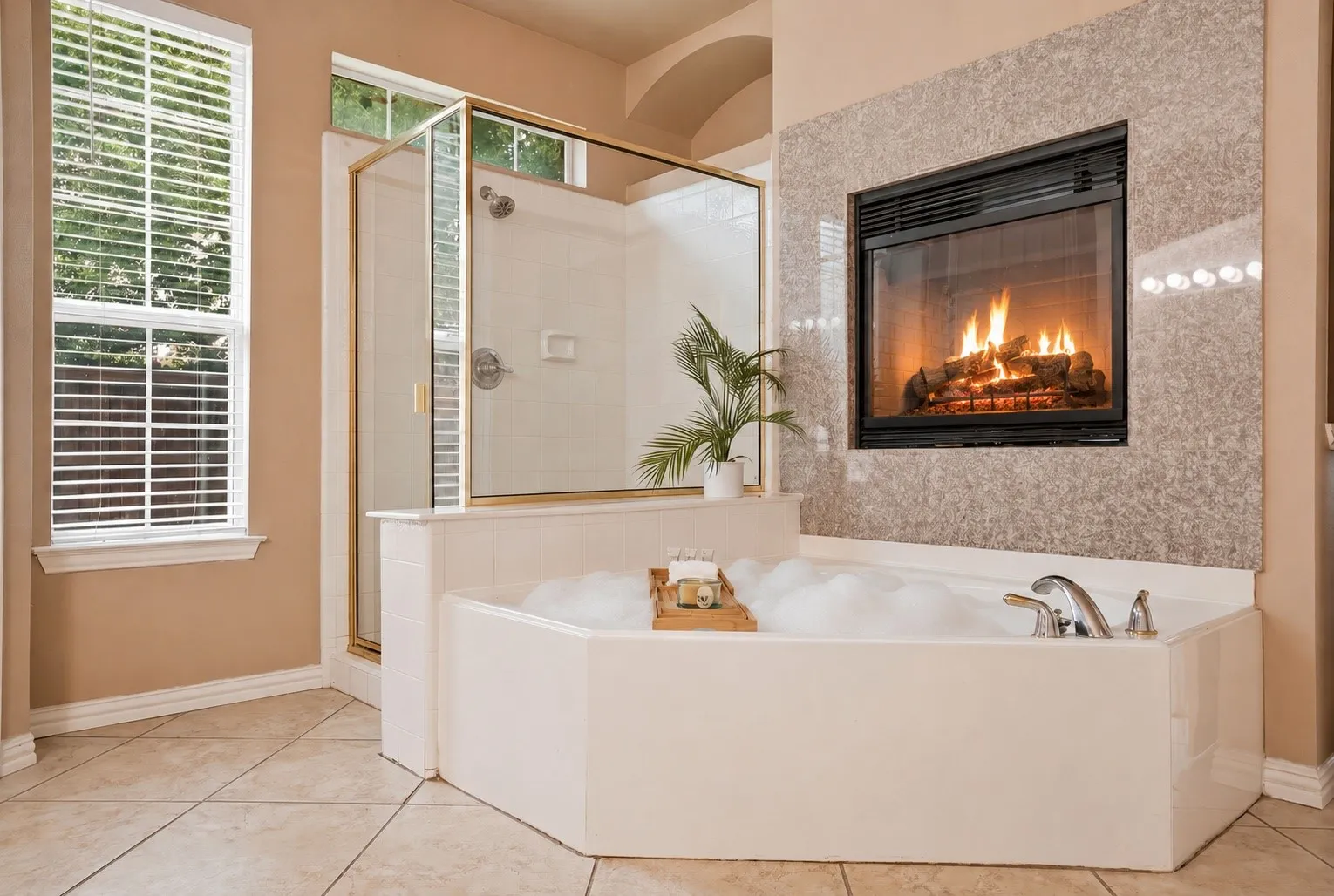 A true spa-inspired ensuite where a jetted soaking tub, dual vanities, and a double-sided fireplace transform daily routines into moments of quiet retreat.