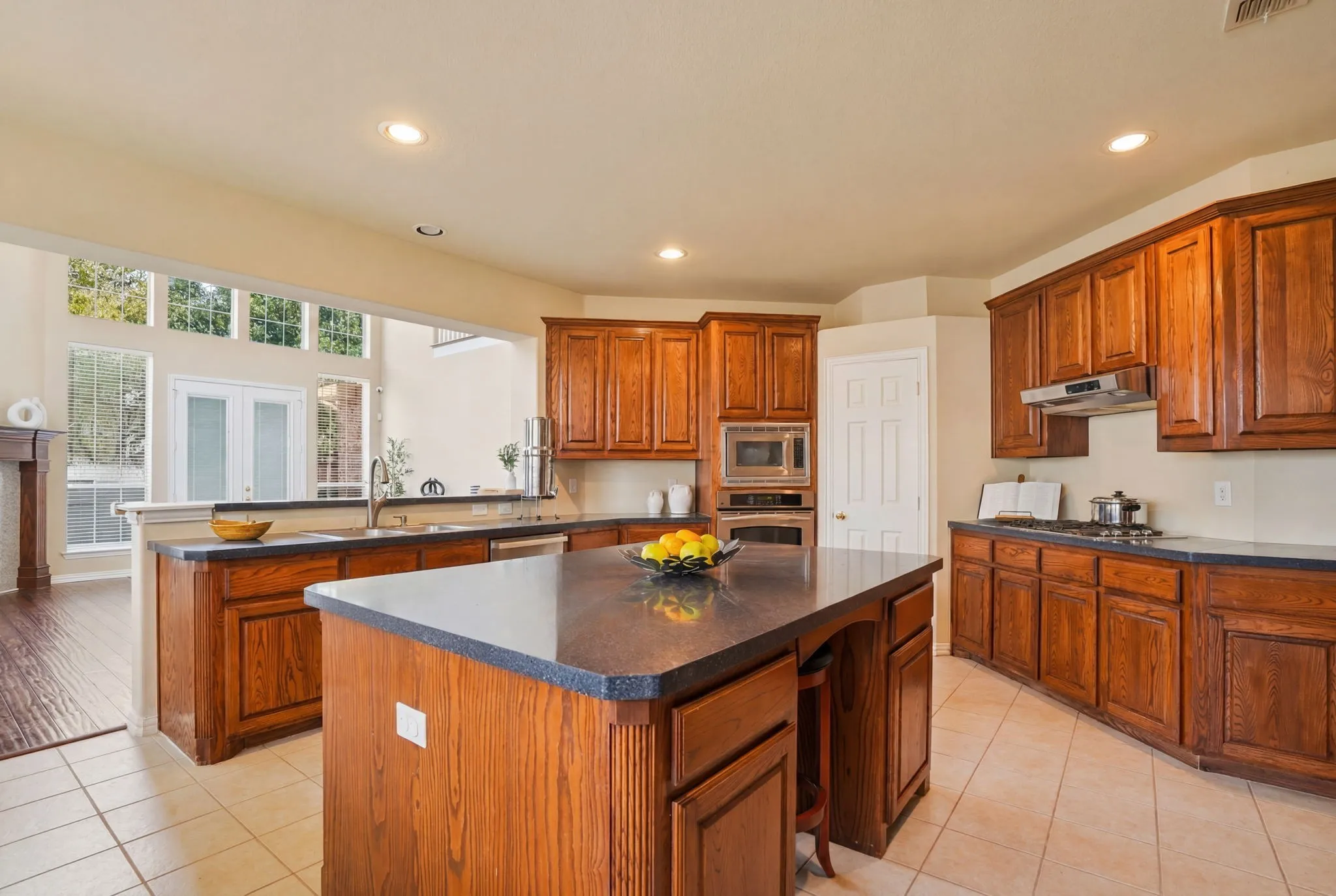 The expansive island anchors the open floor plan, offering the perfect space for casual dining, conversation, and effortless connection with the adjoining living areas.
