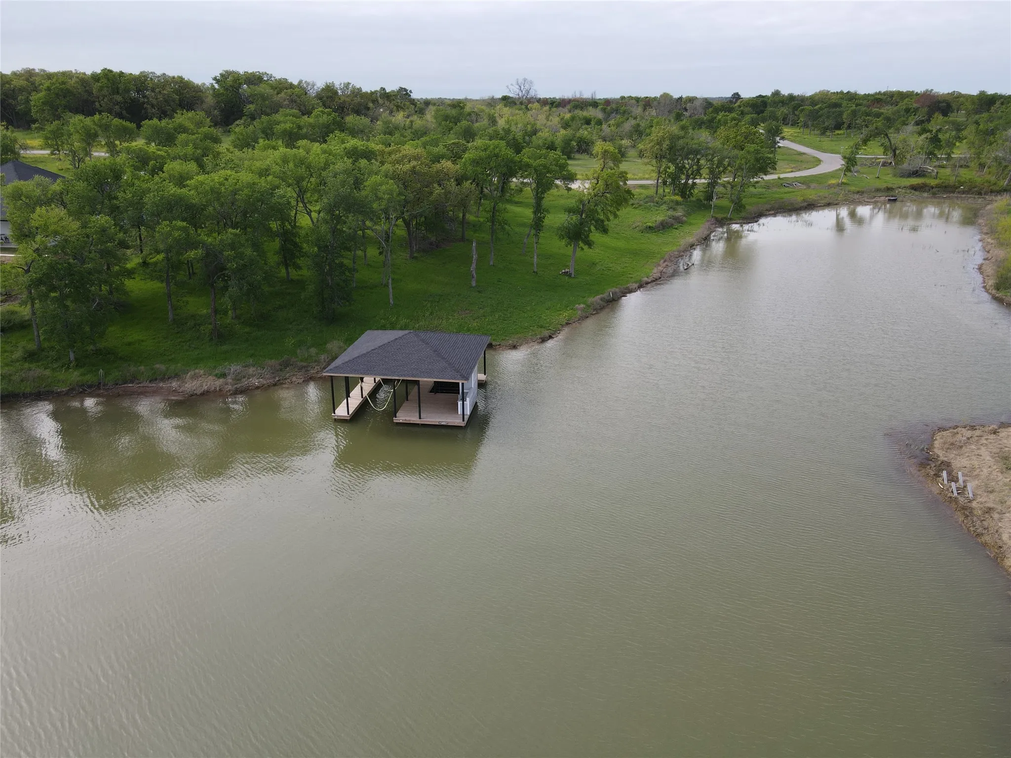 Overhead boathouse view highlights the covered dock, shoreline, and easy access to Richland Chambers Lake.
