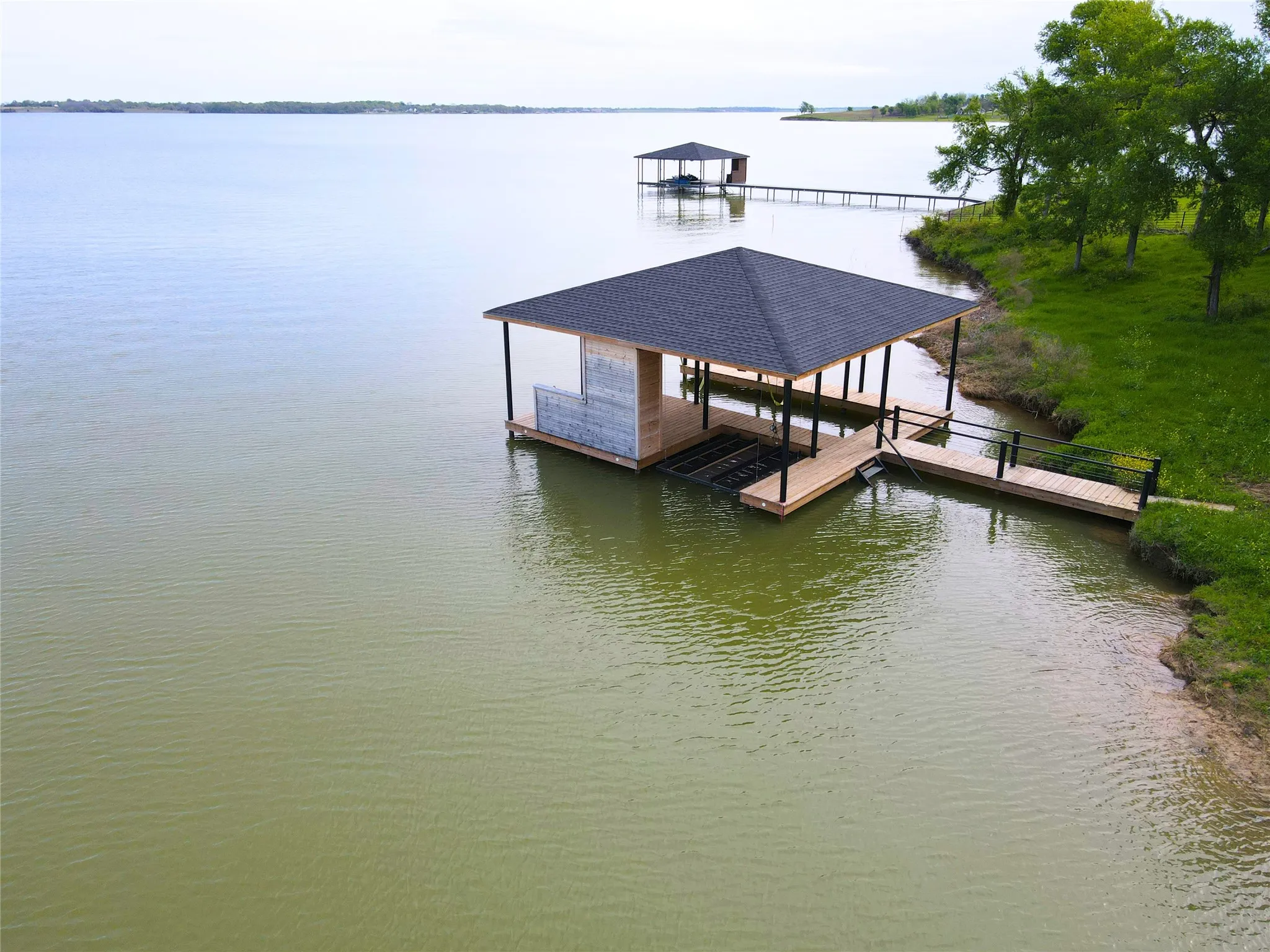 Elevated lake view highlights the boathouse, shoreline, and peaceful setting for a Central Texas waterfront retreat.