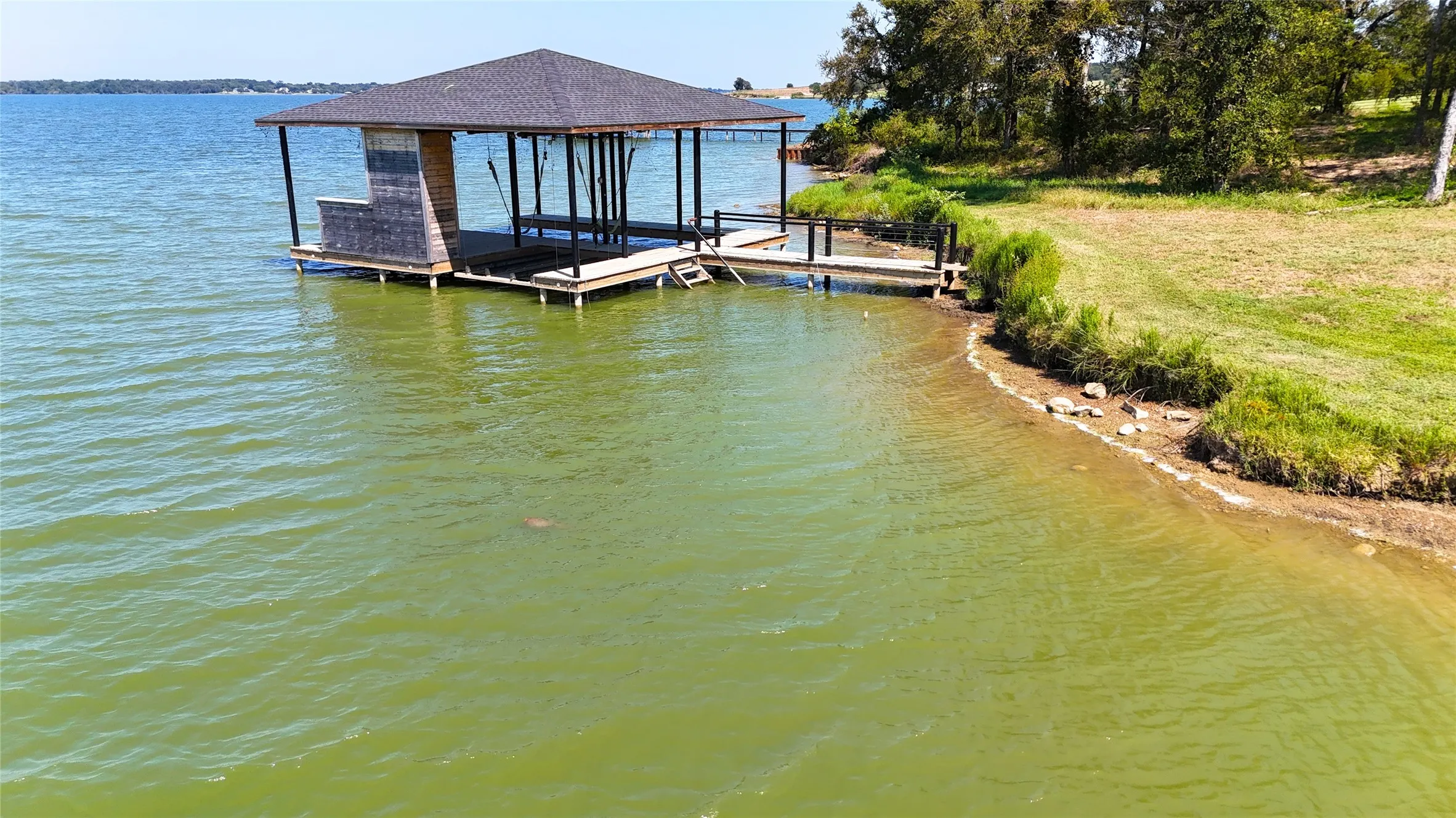 Shoreline view captures the boathouse, gentle water access, and natural lakefront setting in Diamond Point.
