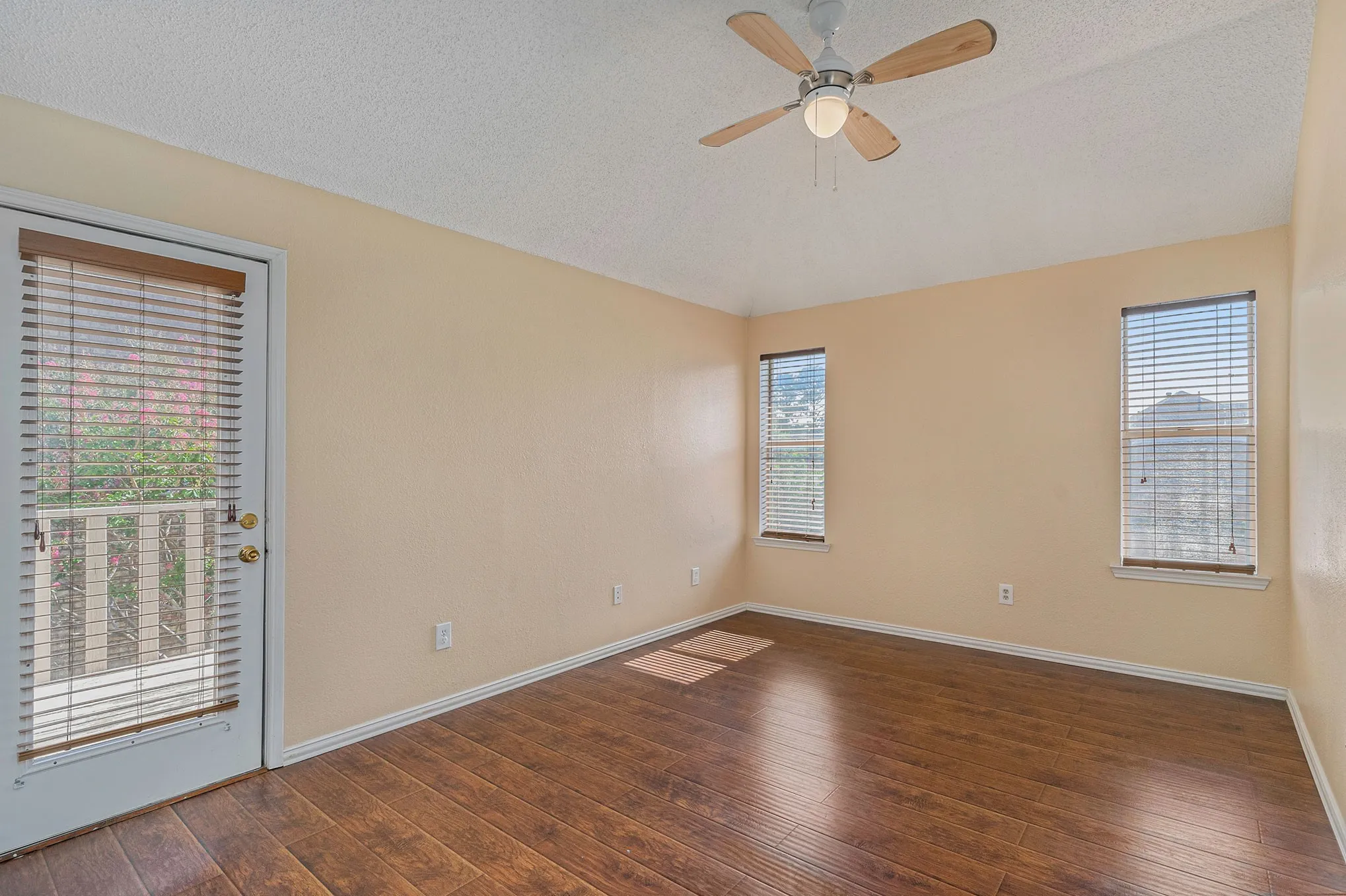 Spare room with ceiling fan, vaulted ceiling, hardwood / wood-style floors, and baseboards