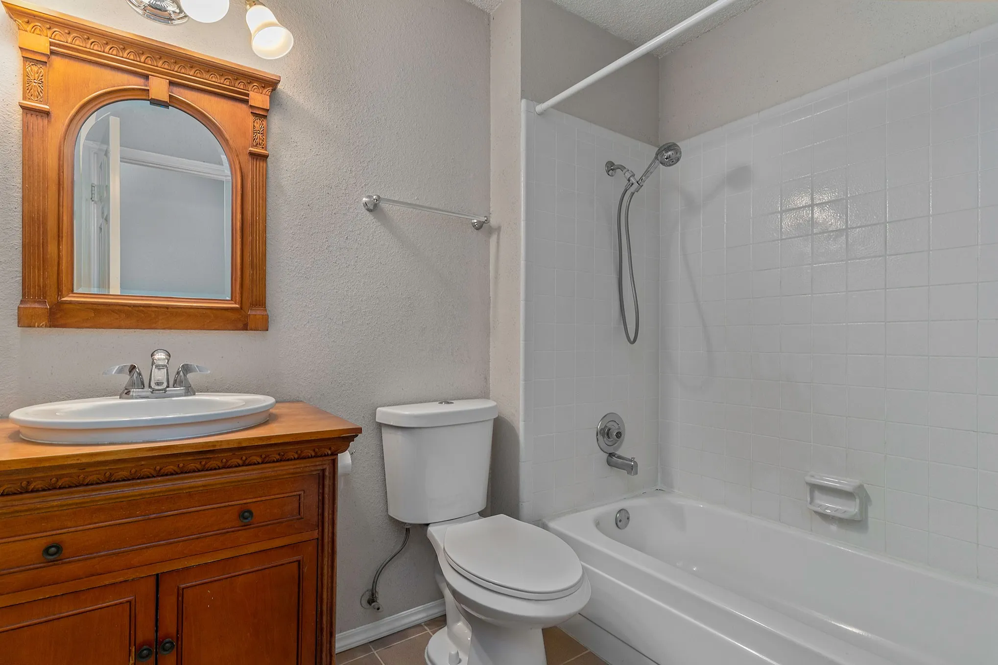 Full bathroom featuring tub / shower combination, vanity, toilet, tile patterned floors, and baseboards