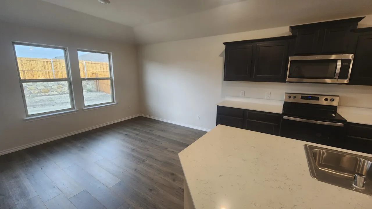 Kitchen featuring dark cabinetry, stainless steel appliances, and light-toned countertops