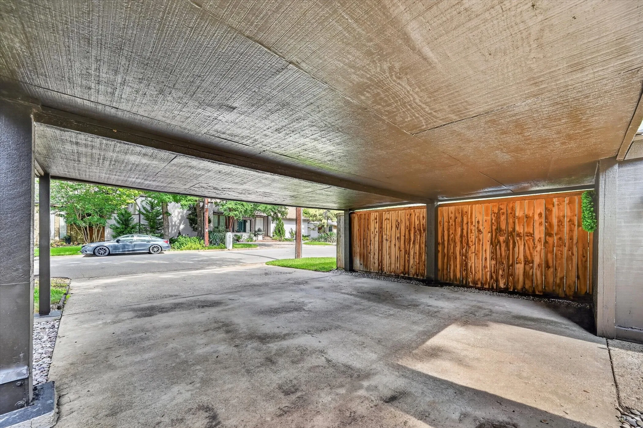 Carport featuring a concrete driveway, textured overhead ceiling