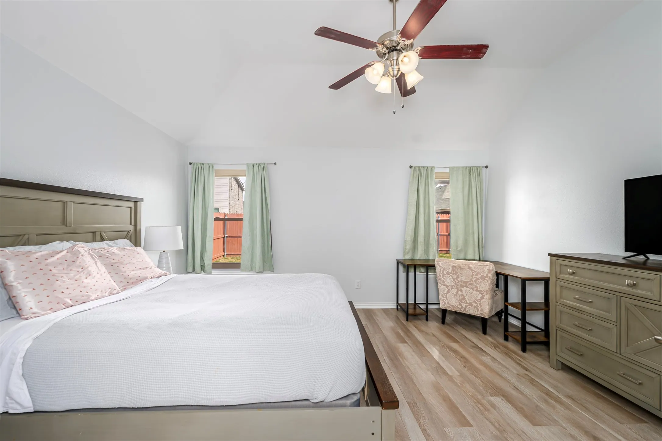 Bedroom with light wood-style flooring, ceiling fan, and vaulted ceiling