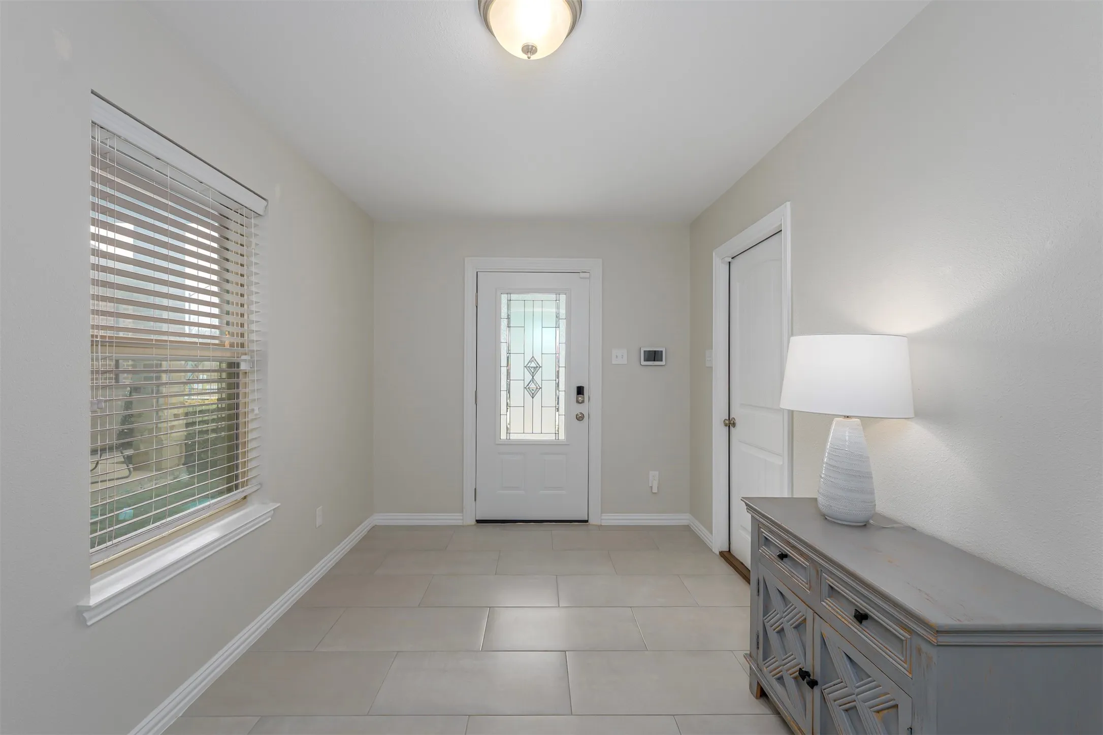 Foyer entrance featuring baseboards and light tile patterned flooring