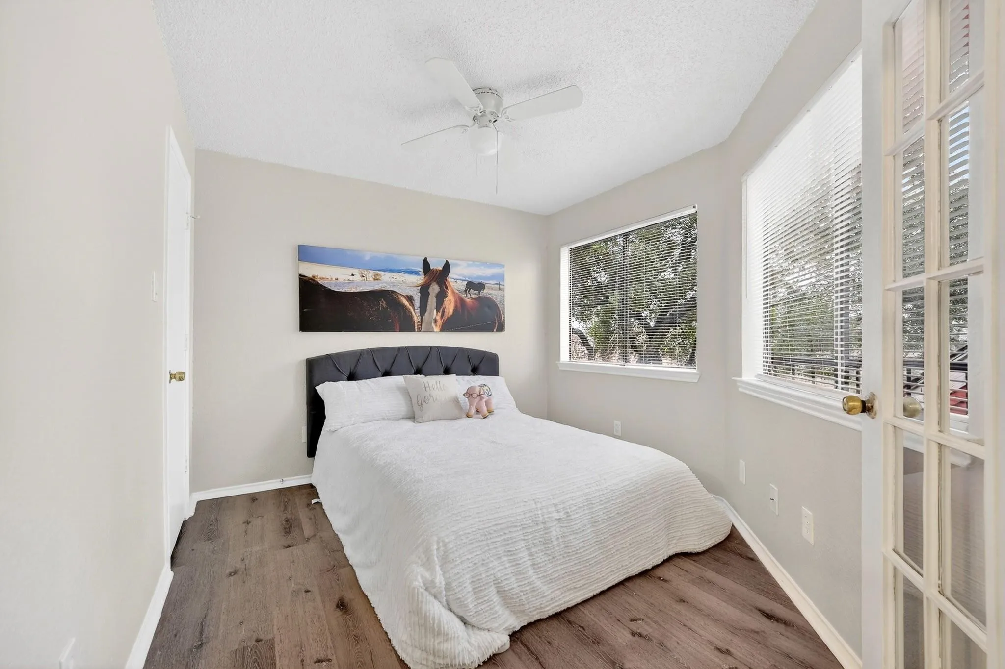 Interior room featuring wood-finish flooring, a ceiling fan, and light-toned walls