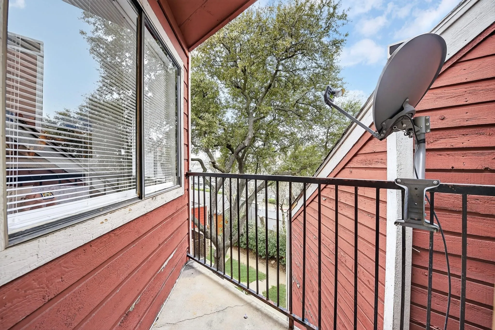 Outdoor balcony featuring a black metal railing and concrete flooring