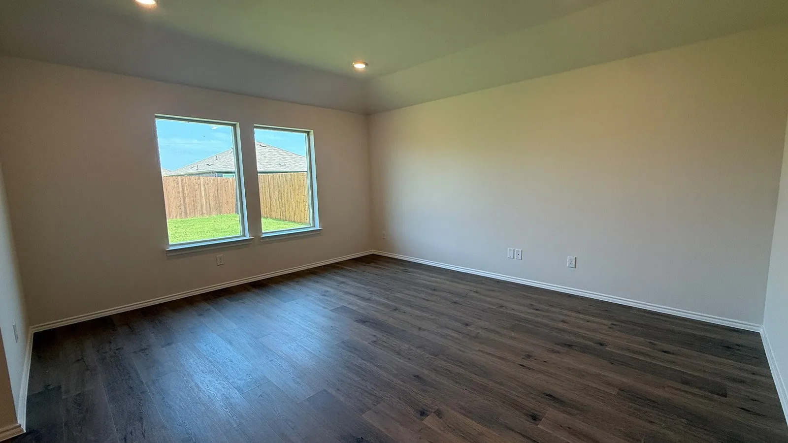 Spacious room featuring wood-finish flooring, recessed lighting, and a neutral color palette