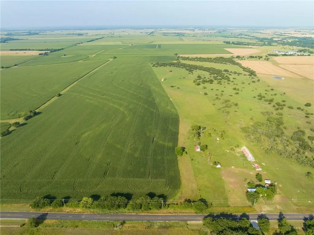 Expansive land parcel featuring cultivated fields, open grassy areas, and scattered trees
