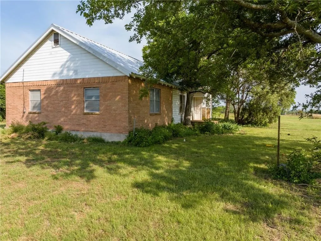 Brick-clad exterior with a white gable roof and white siding