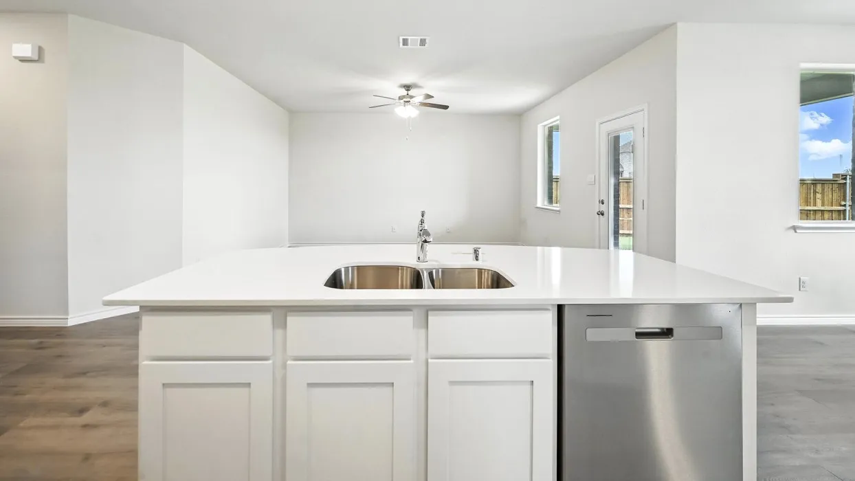 Kitchen island featuring a stainless steel double sink, a stainless steel dishwasher, and white shaker-style cabinetry
