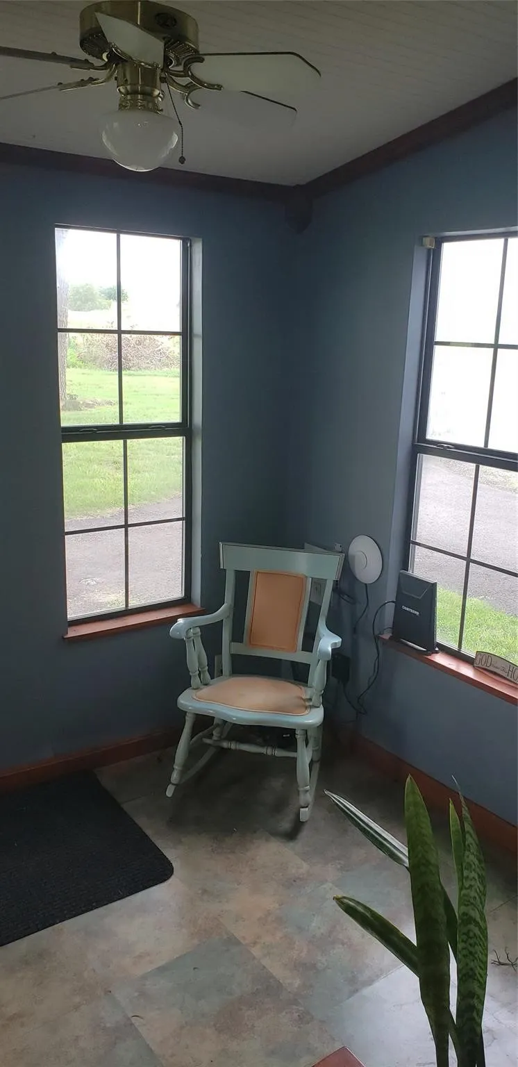 Sitting room featuring ceiling fan and tile patterned floors