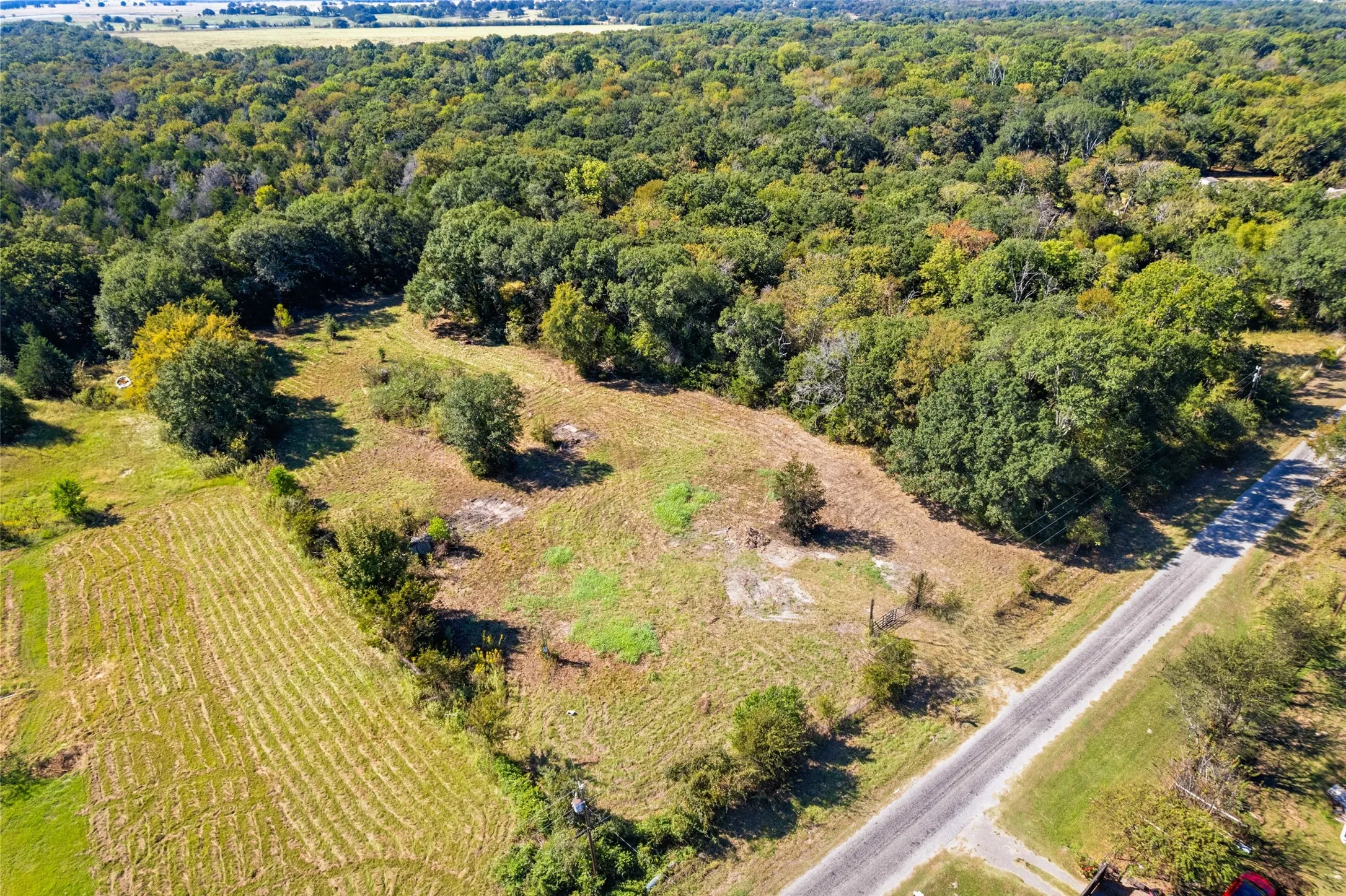 Expansive land parcel featuring a mix of cleared areas and mature tree coverage
