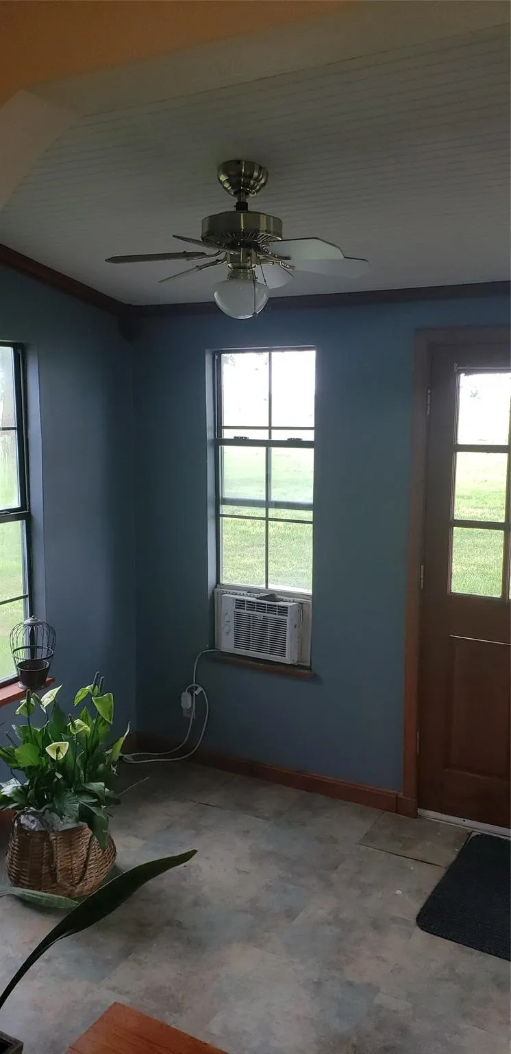 Entrance foyer with cooling unit, ceiling fan, and a healthy amount of sunlight