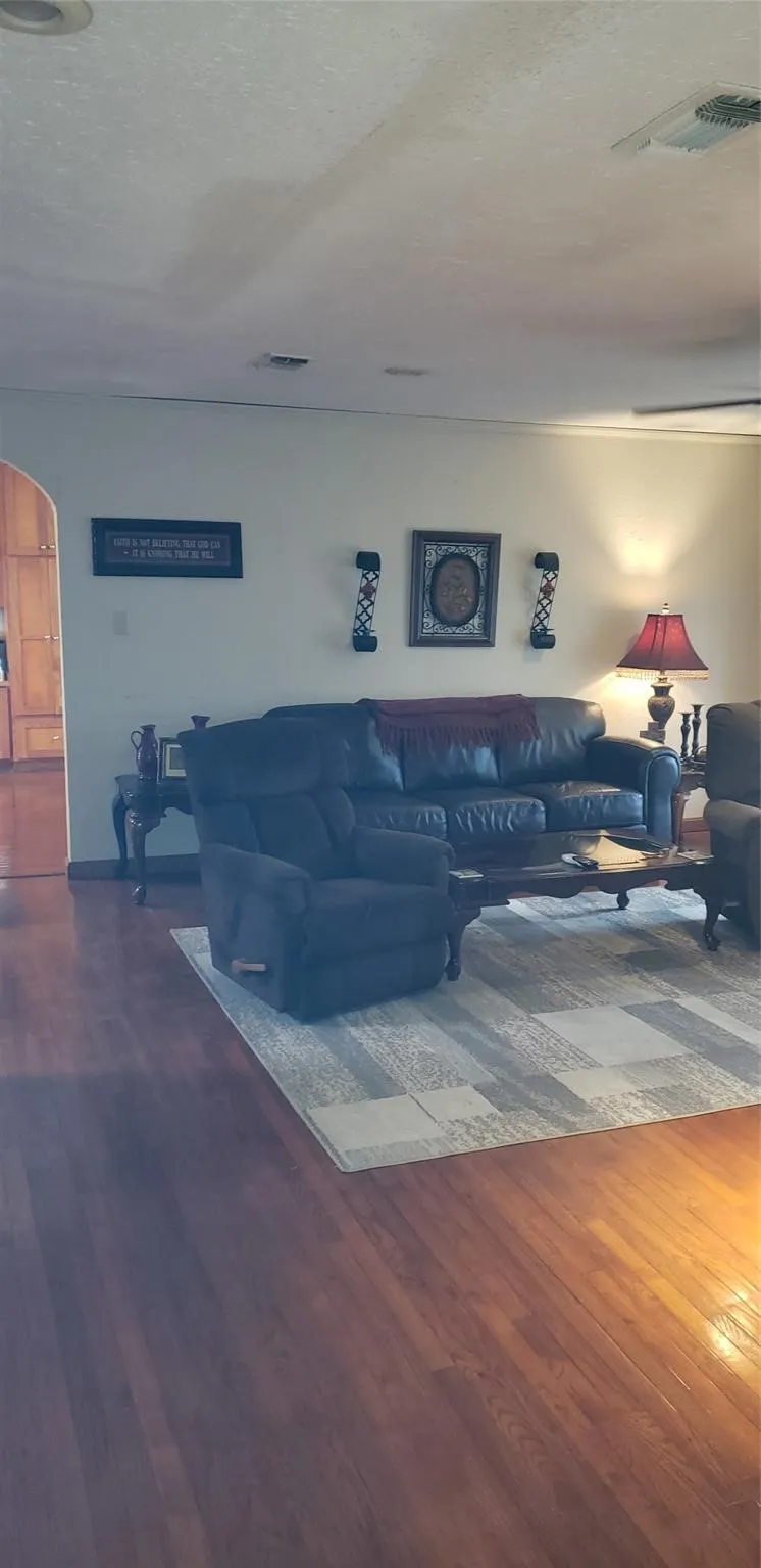Living room featuring a textured ceiling and hardwood / wood-style flooring