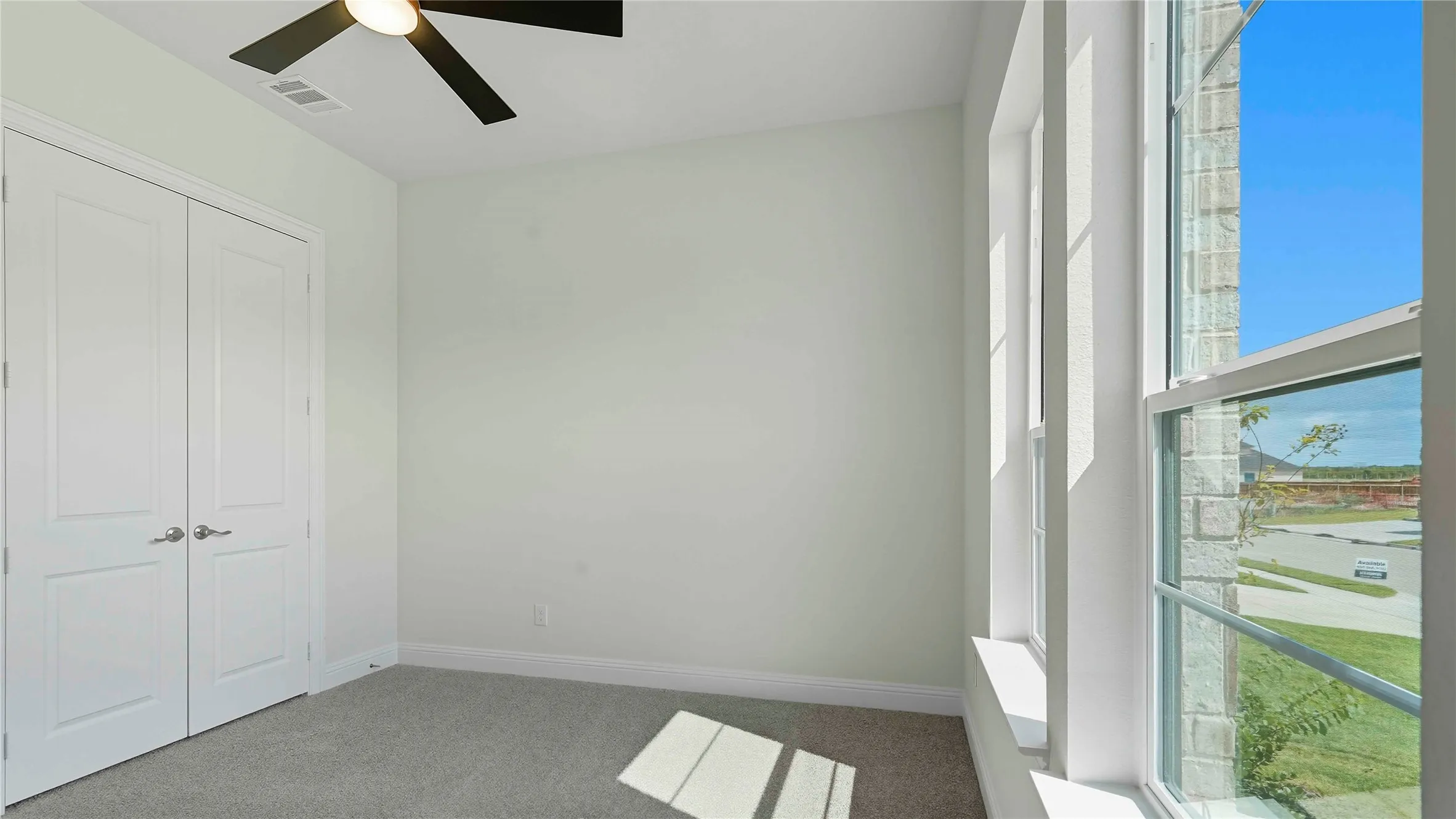 Room featuring light-colored walls, grey carpeting, and white trim