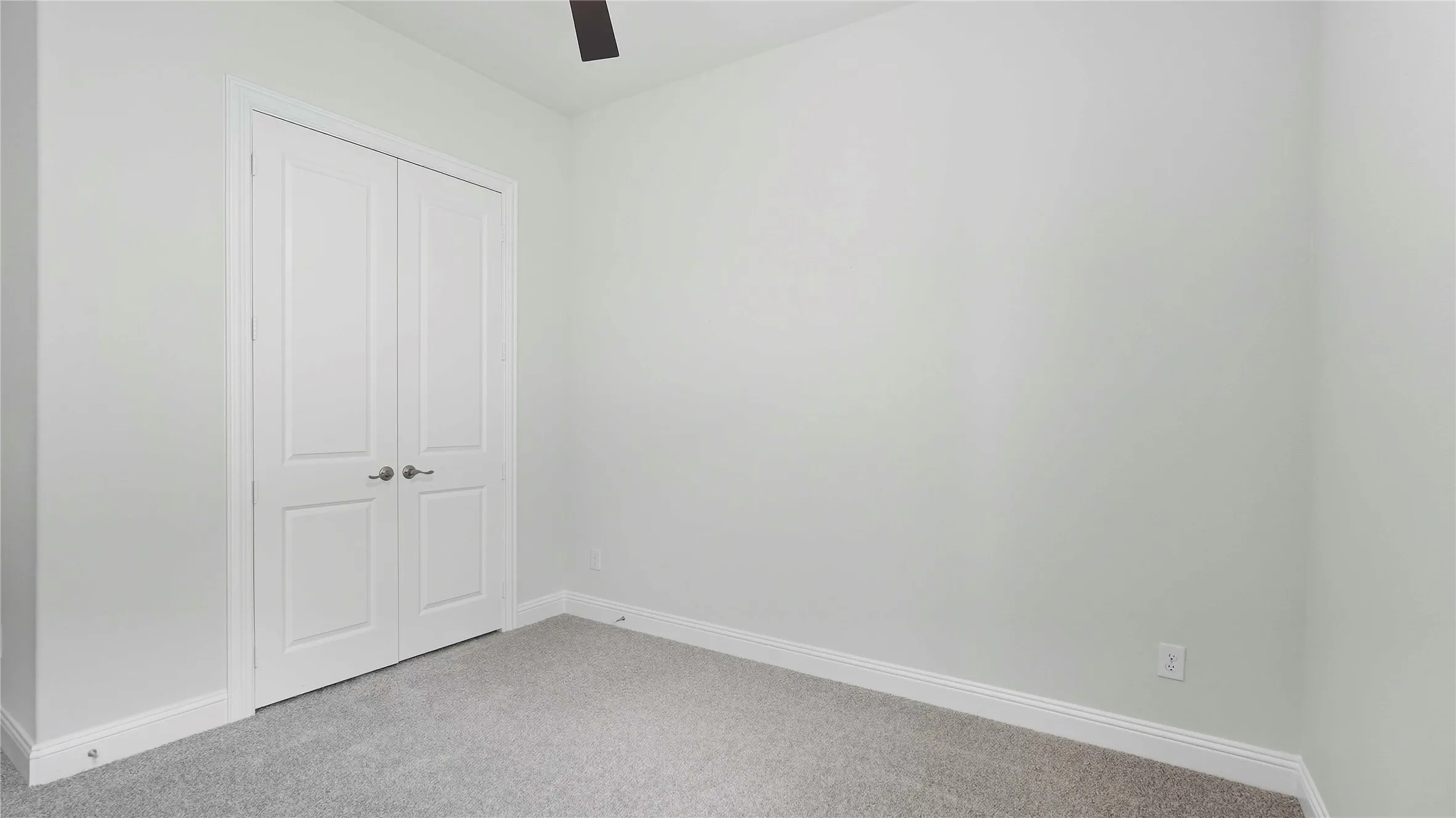 Light gray wall paint complements the gray carpeting