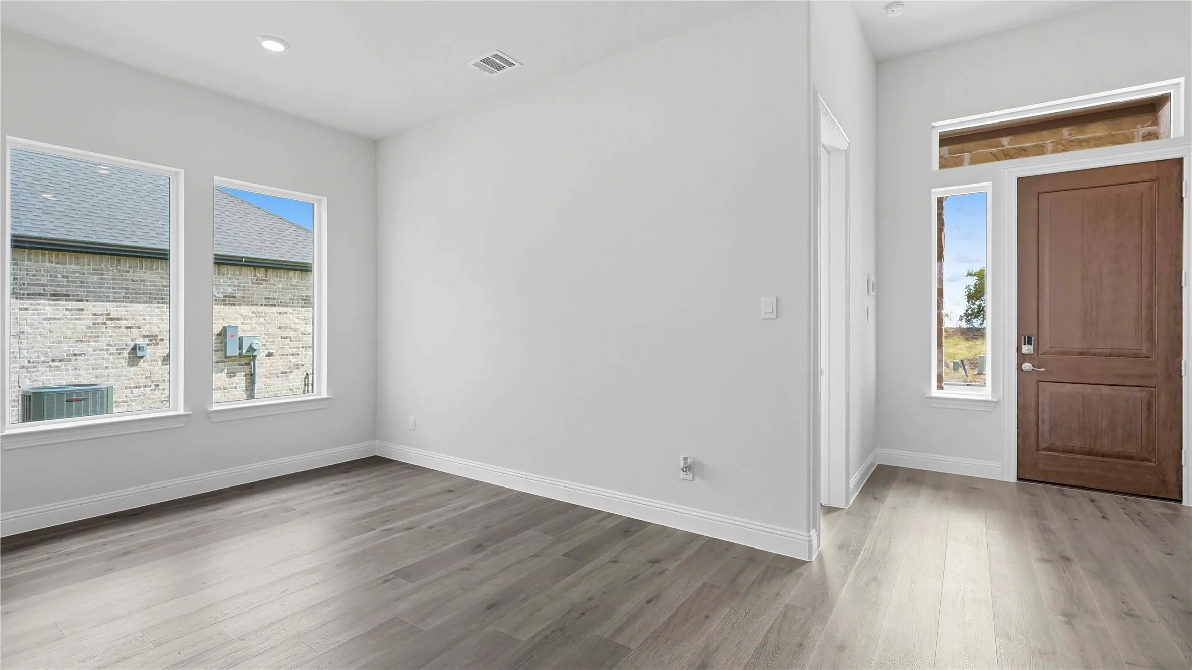 Entryway featuring a wood-finish door with sidelight and transom, light gray wood-finish flooring, recessed lighting, and white baseboards