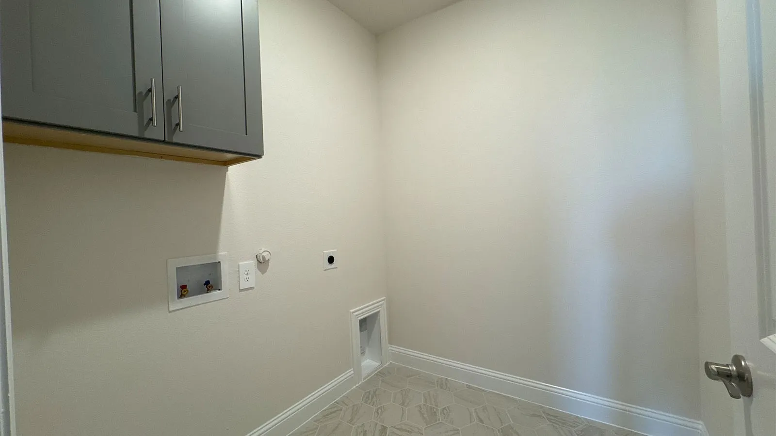 Light-toned walls with grey upper cabinetry featuring brushed nickel hardware