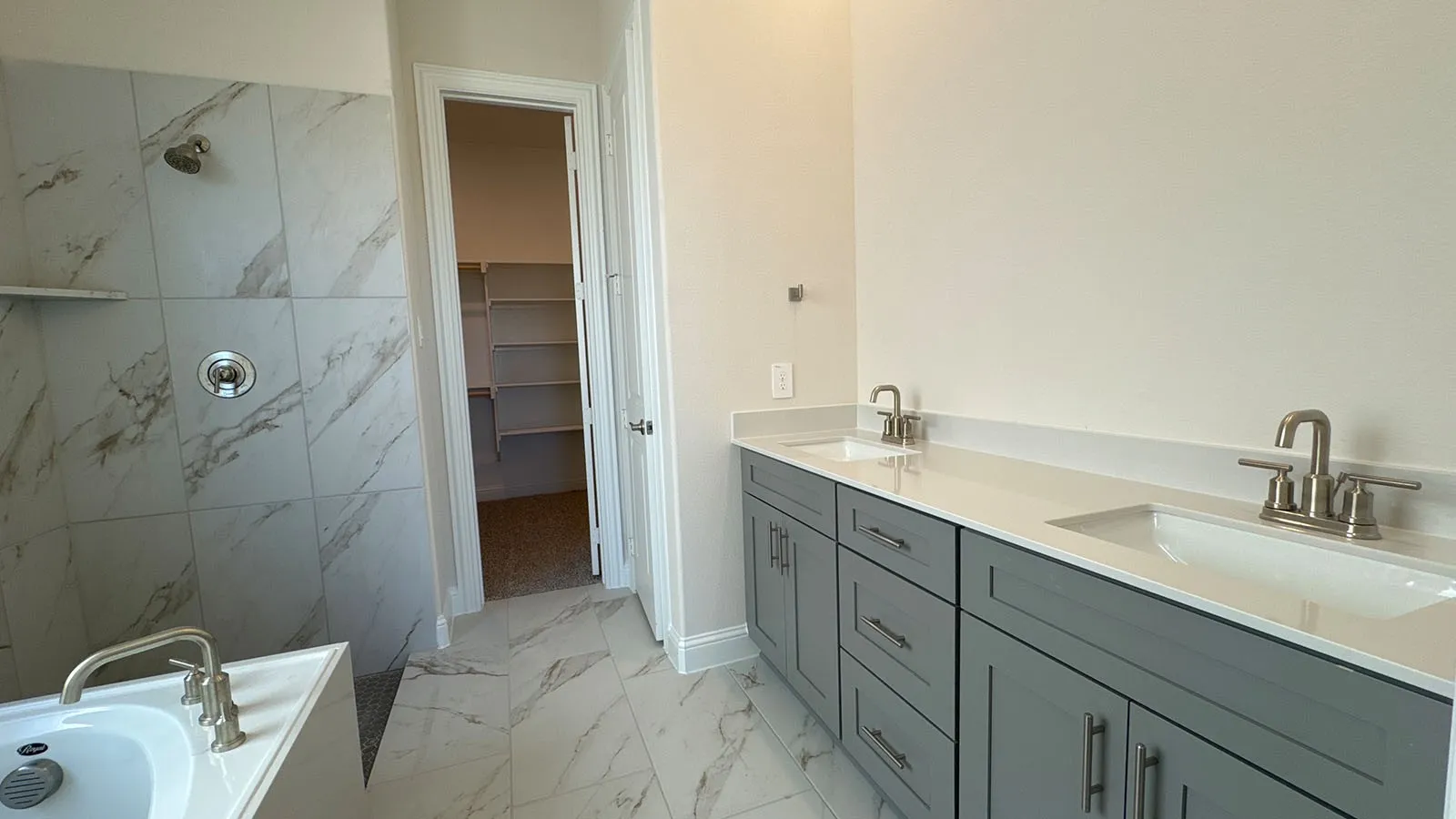 Dual vanity with gray cabinetry, white countertops, and undermount sinks