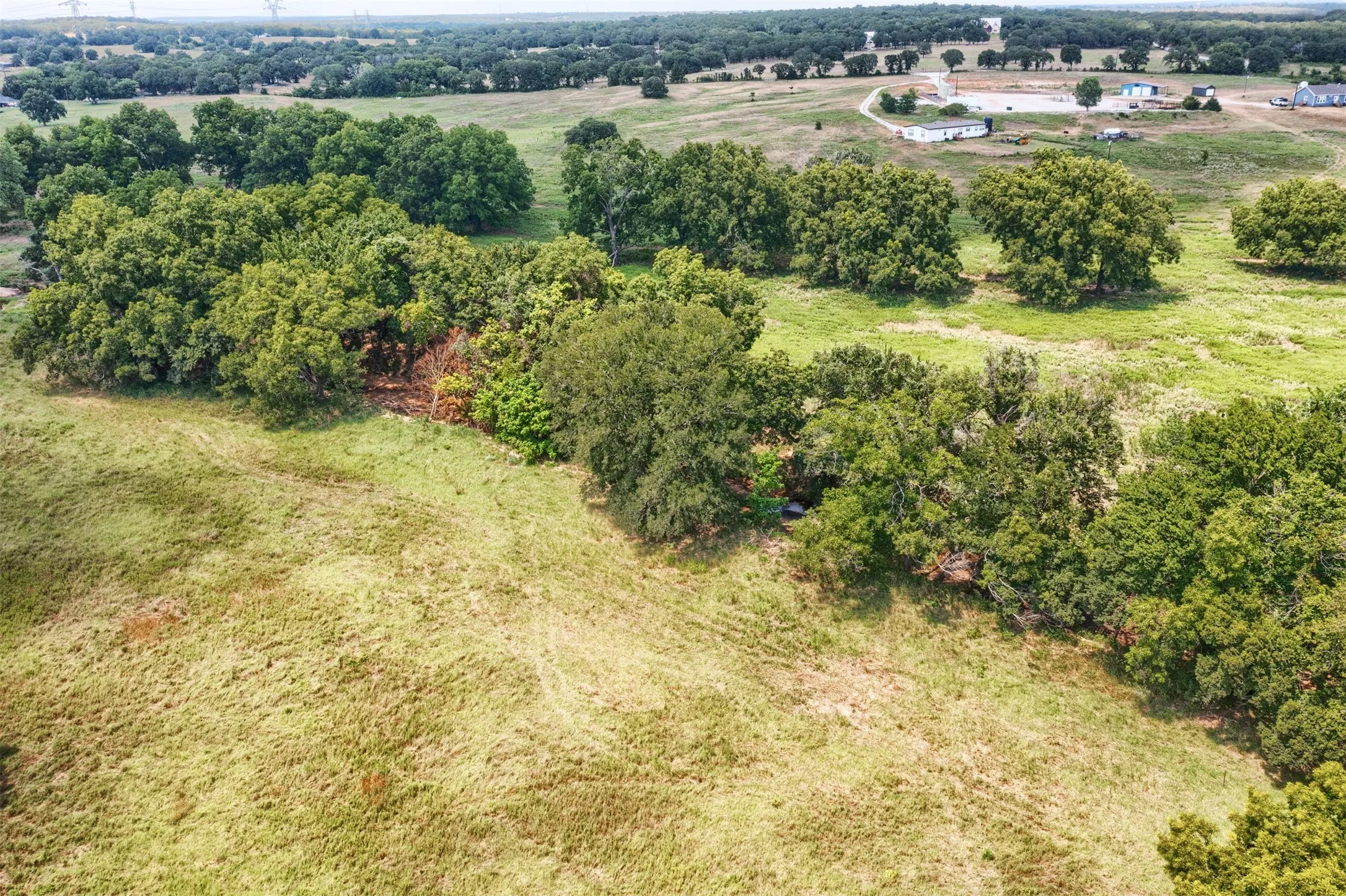 Expansive green acreage featuring mature trees and open fields