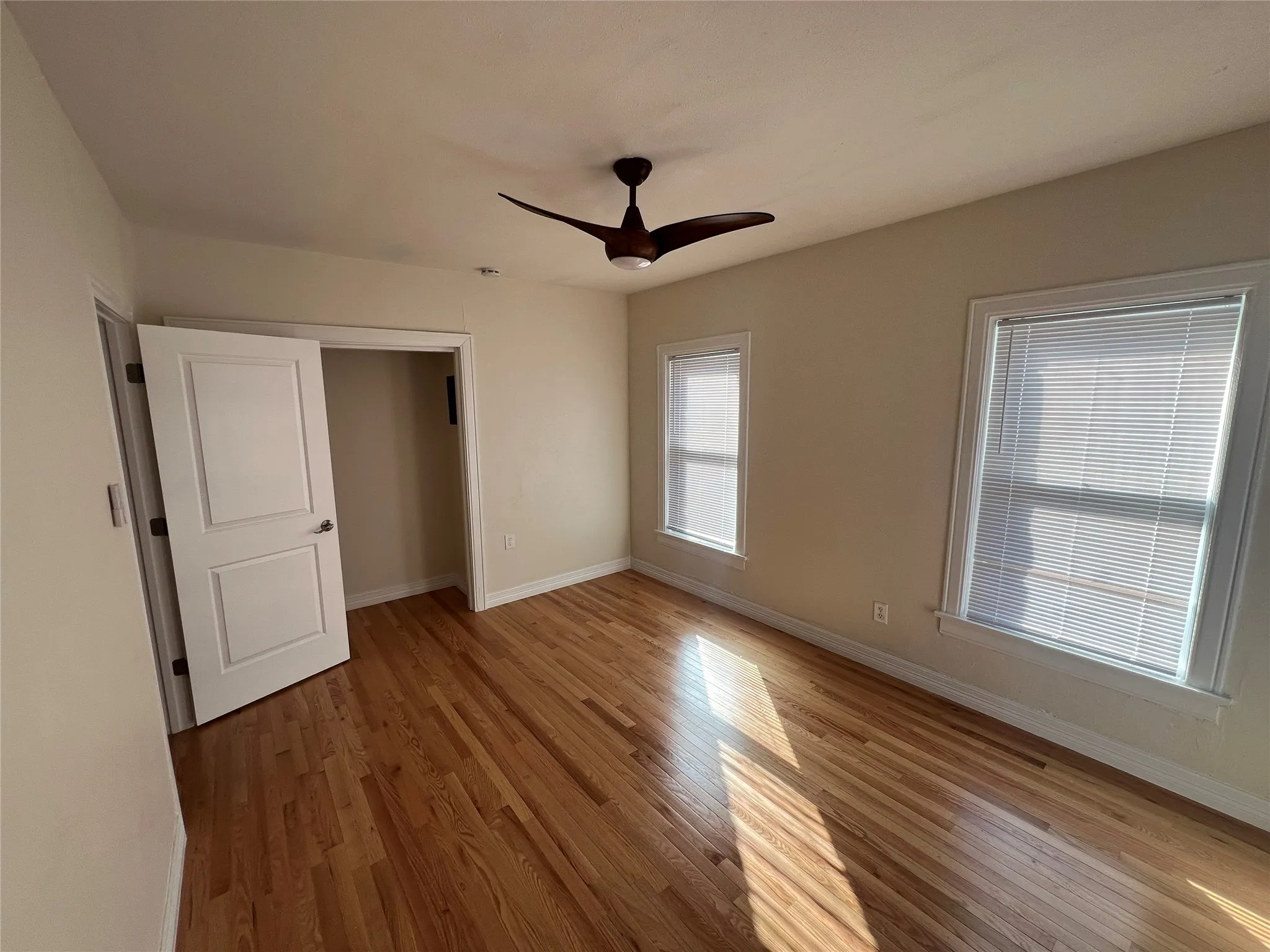 Unfurnished bedroom with ceiling fan, light wood-type flooring, and a closet