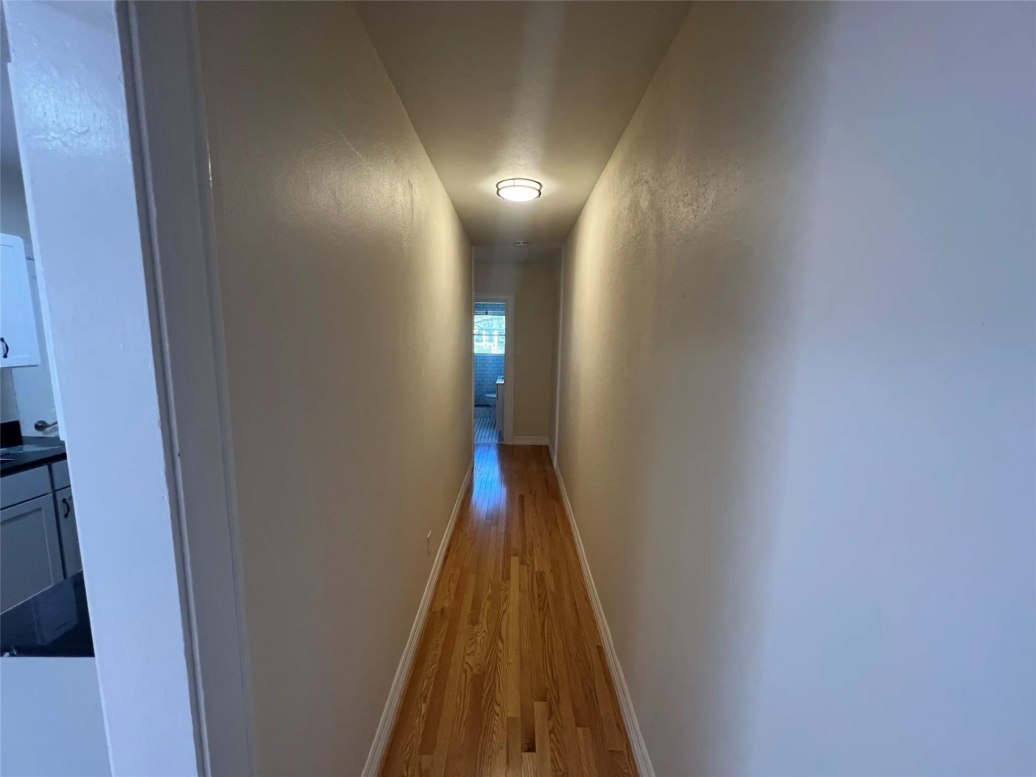 Corridor with light hardwood / wood-style flooring
