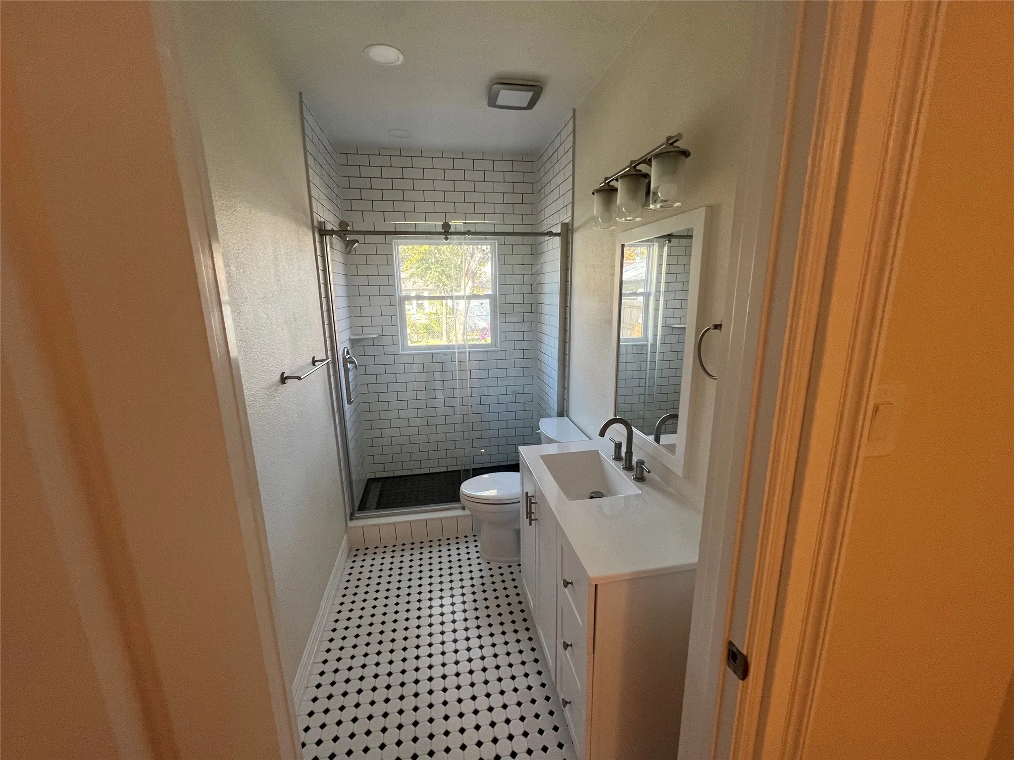 Bathroom with vanity, toilet, and a shower with door