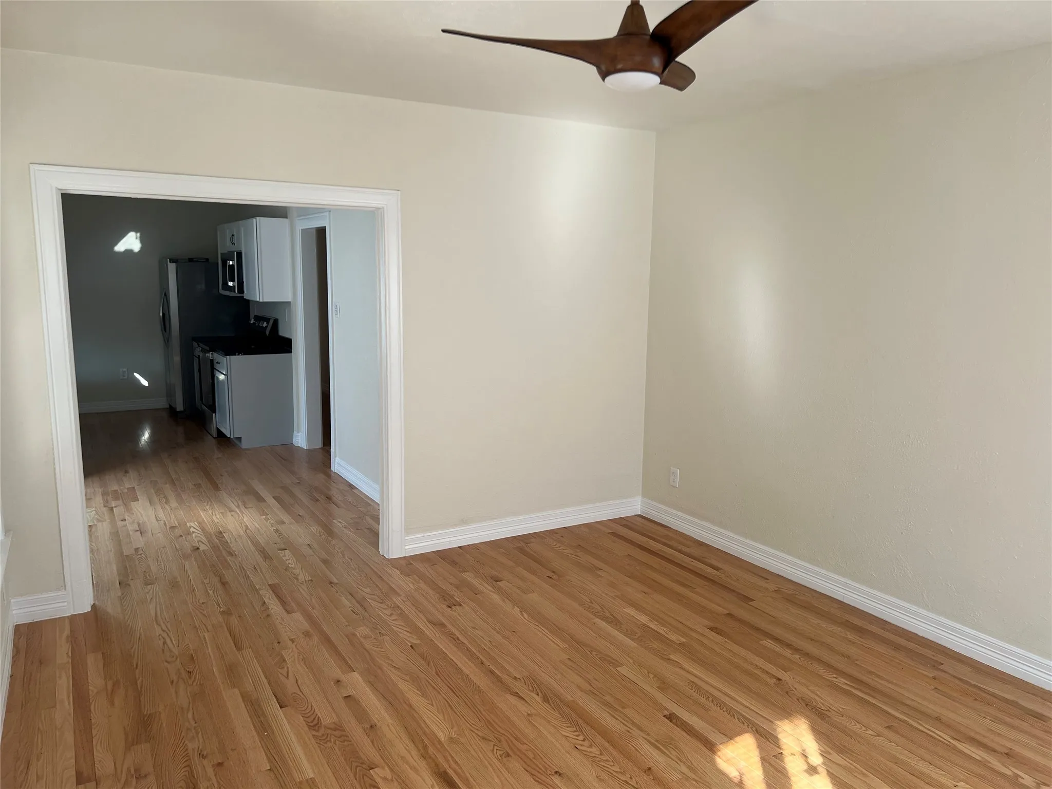Unfurnished room with light wood-type flooring and ceiling fan