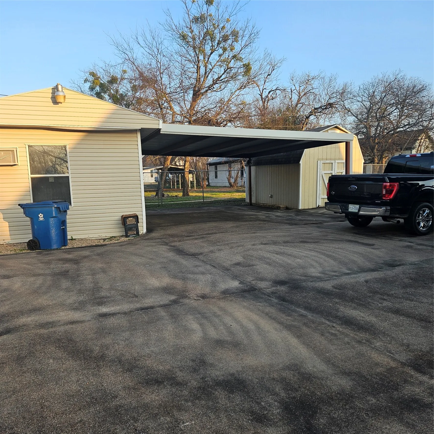 car port, paved parking area, shop and additional storage building