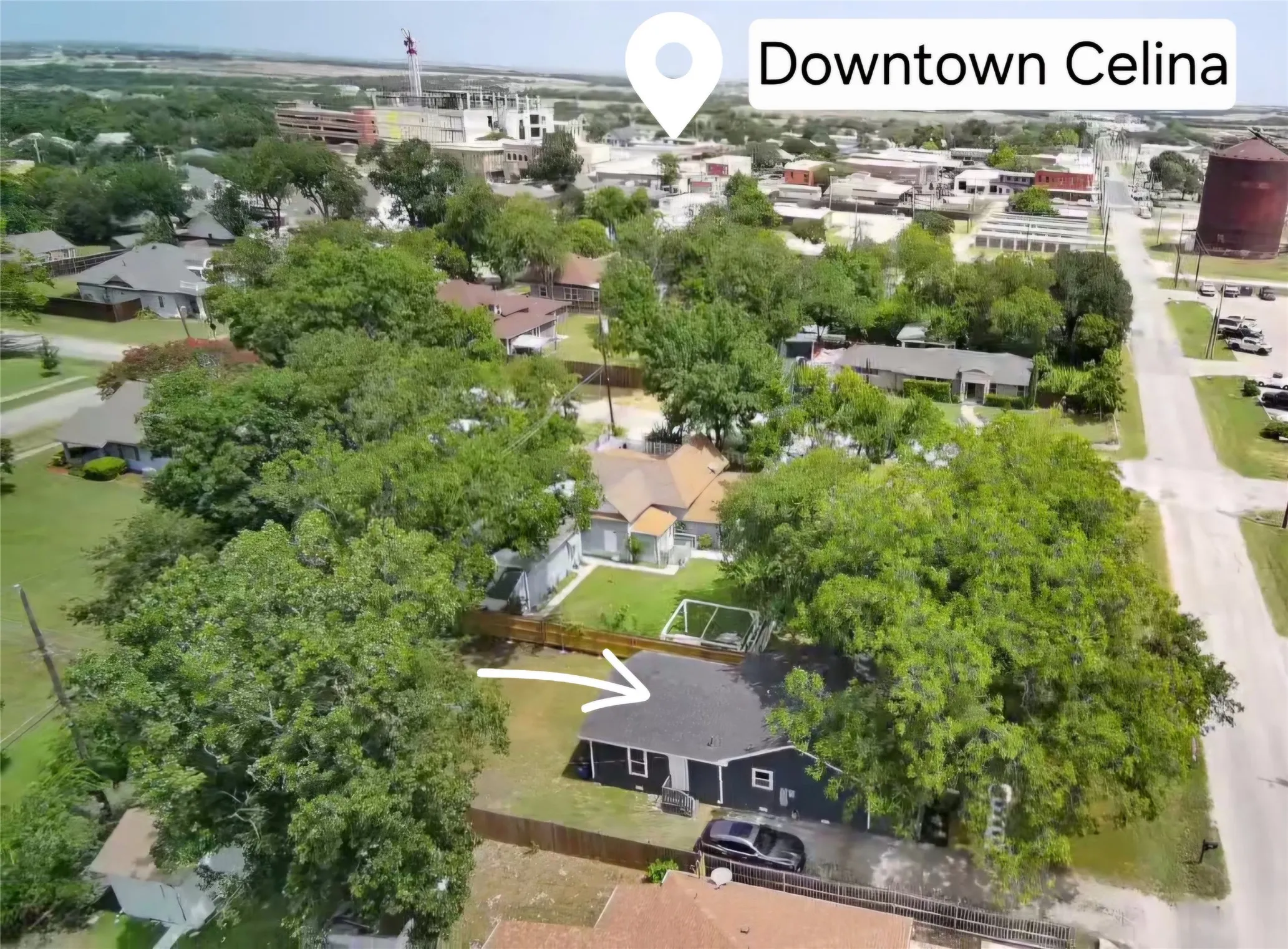 Aerial perspective showcasing a residential property with a dark-sided exterior and a gray-shingled roof
