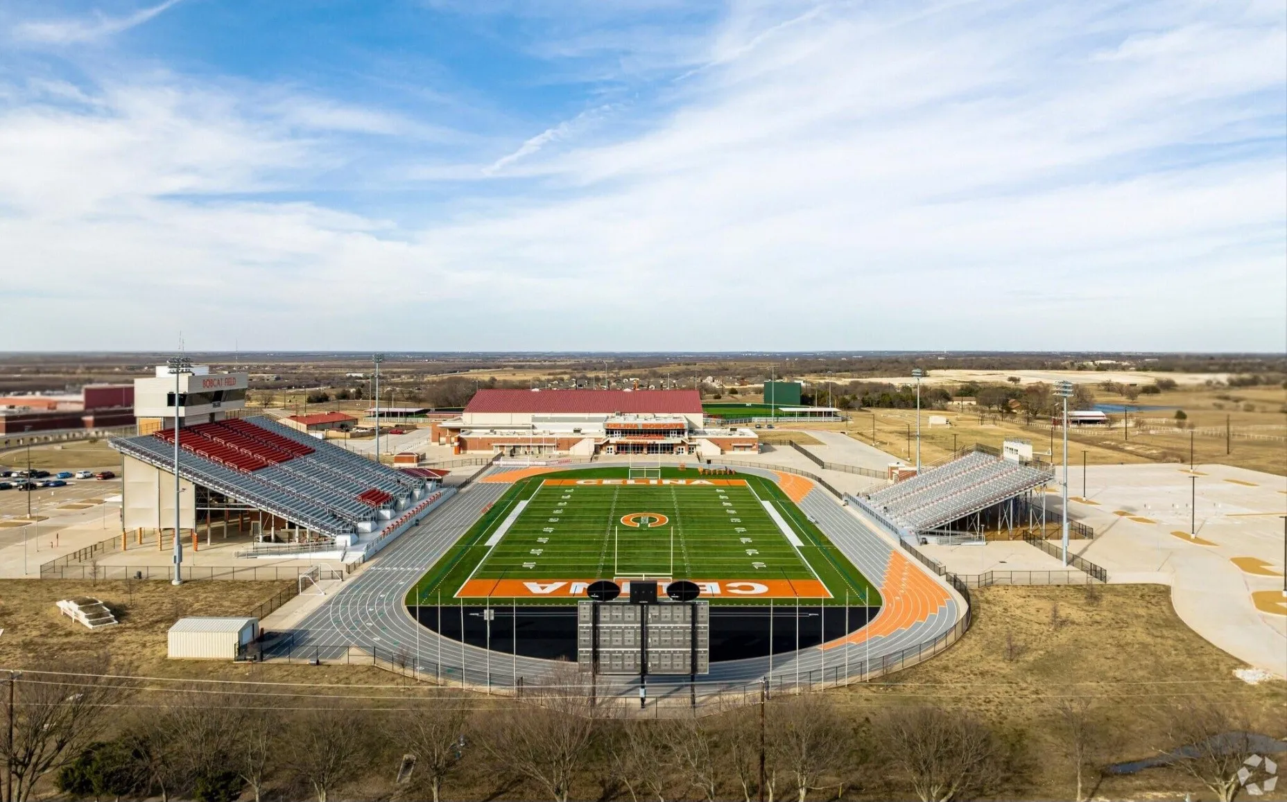Athletic stadium featuring a vibrant green turf field with orange accents