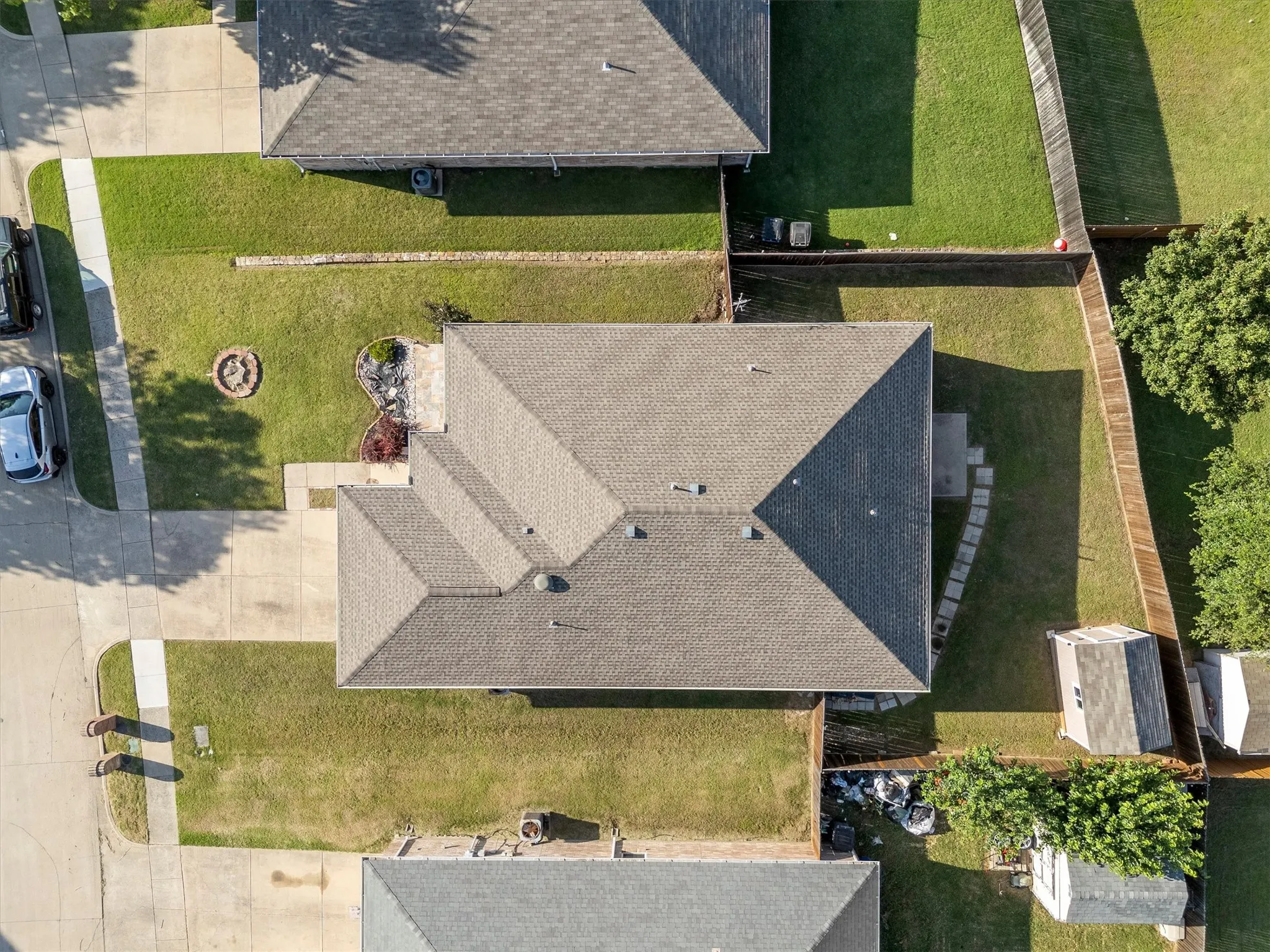 Gable roof structure over a single-story residence with a concrete driveway and sidewalk