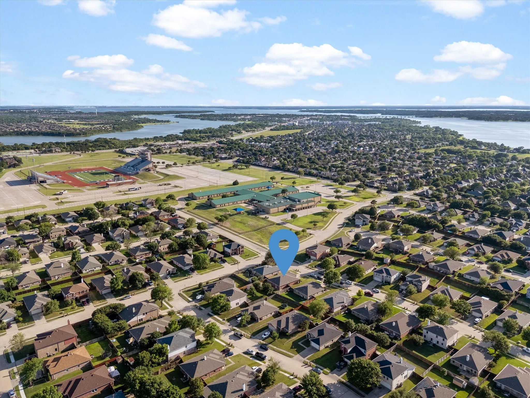 Aerial perspective showcasing the residential neighborhood with a prominent body of water in the background