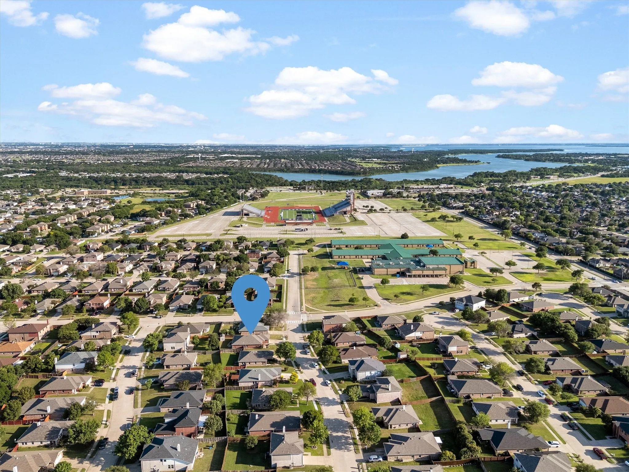Aerial perspective showcasing a residential neighborhood with a large body of water in the background