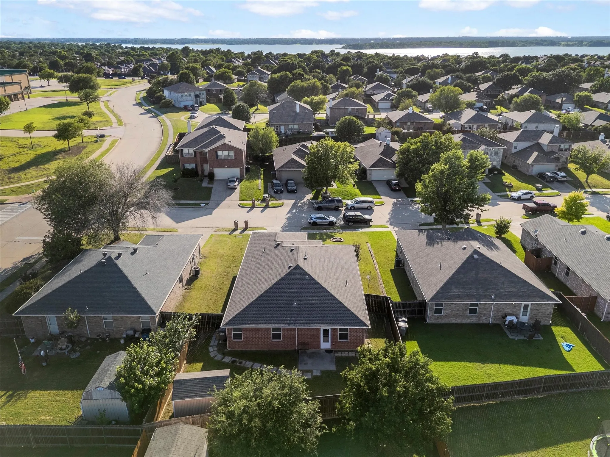 Aerial perspective showcasing a residential neighborhood with a distant body of water