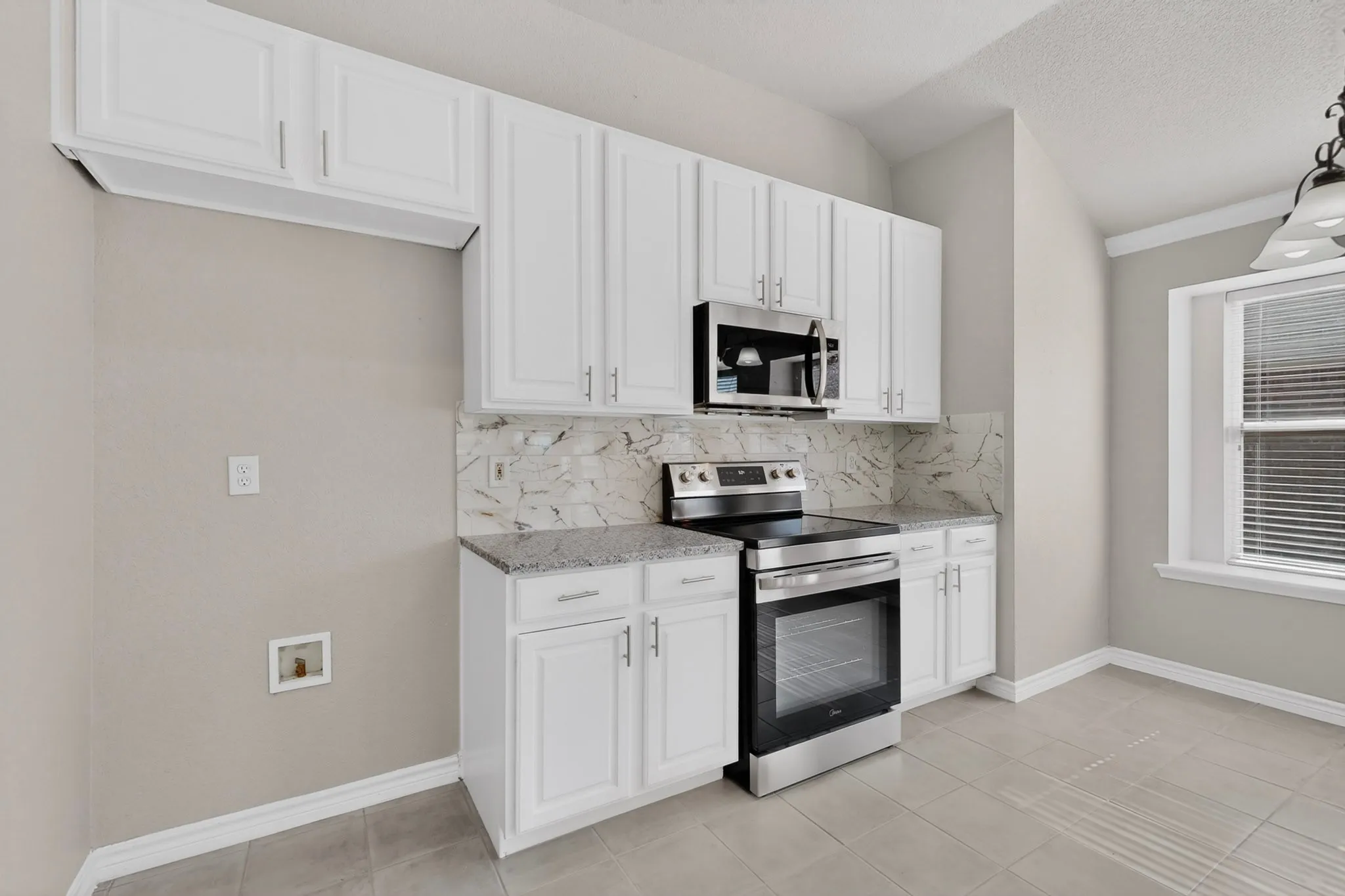 Another Angle of the Kitchen with New Stove, Microwave, Granite Countertop and New Ceramic Tile Flooring
