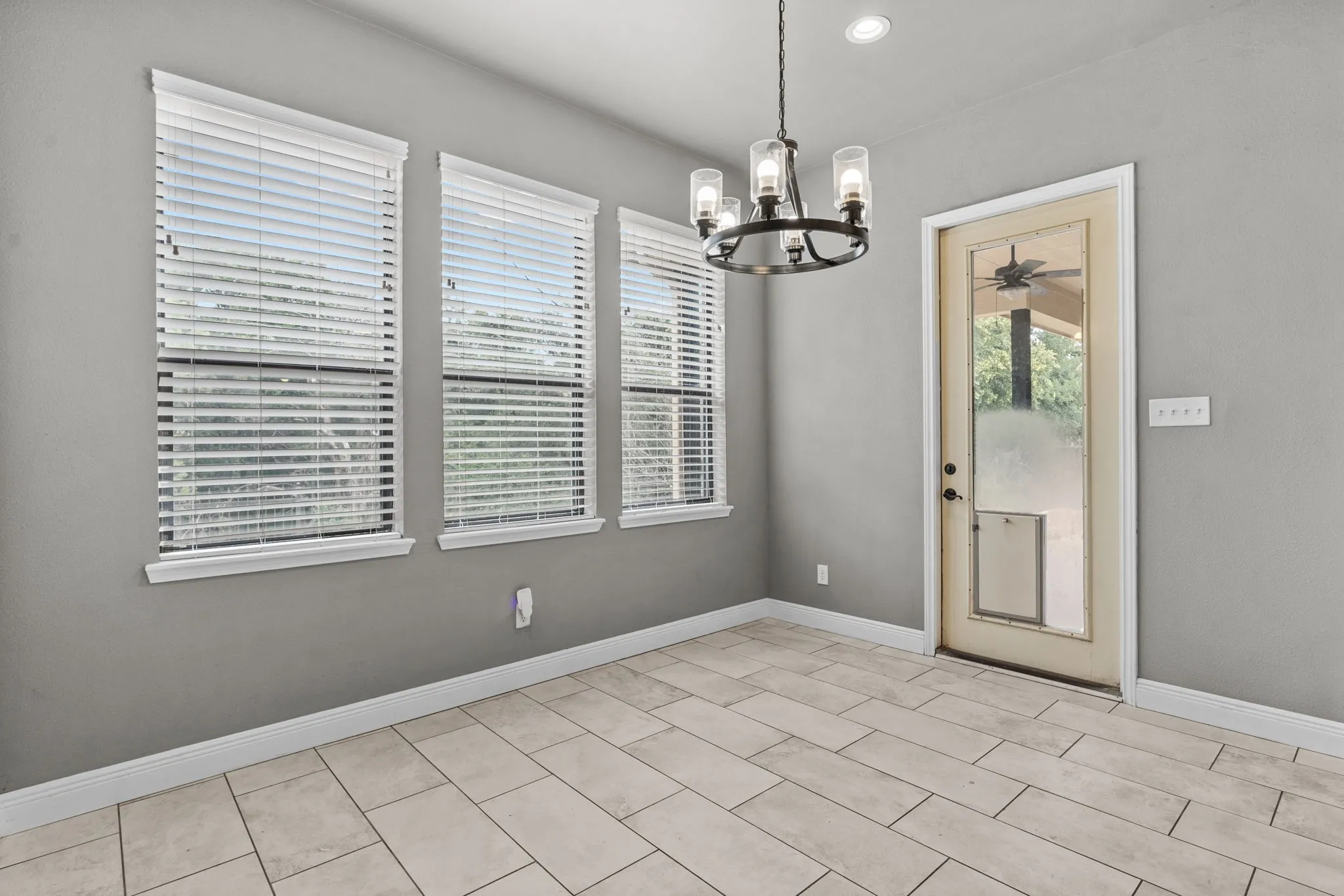 Unfurnished dining area featuring a notable chandelier and light tile patterned floors